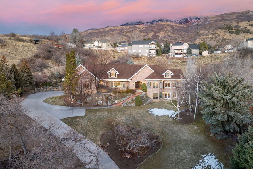 Private lot in Provo's coveted Brookshire Circle, this meticulously updated home sits on a fully developed 0.92-acre lot featuring terraced landscaping, rock accents, a basketball court, and a pad ready for a pool or trampoline. You have full valley views from here, and stunning sunsets. The home has vaulted ceilings on the main, an open family room and kitchen with a double-sided fireplace, white cabinetry, bar seating, and a multi-tiered deck perfect for entertaining. The expansive primary suite offers plantation shutters, a private patio, and a luxurious bath with dual sinks and a two-headed shower. Upstairs, two generous bedrooms share a Jack-and-Jill bath, while the basement is a fully equipped with a mother-in-law apartment with a kitchen, separate entry, two bedrooms and a bath, as well as a full guest suite with laundry. Mechanically updated with a new roof (2025), AC, furnaces, and a 100-gallon water heater, the home also features a built-in vacuum, hardwood floors, and stays fully furnished, including a plow-equipped ATV and riding lawnmower. Outside, enjoy a waterfall, gazebo, and panoramic valley views-ready to move in and experience the best of comfort and luxury.