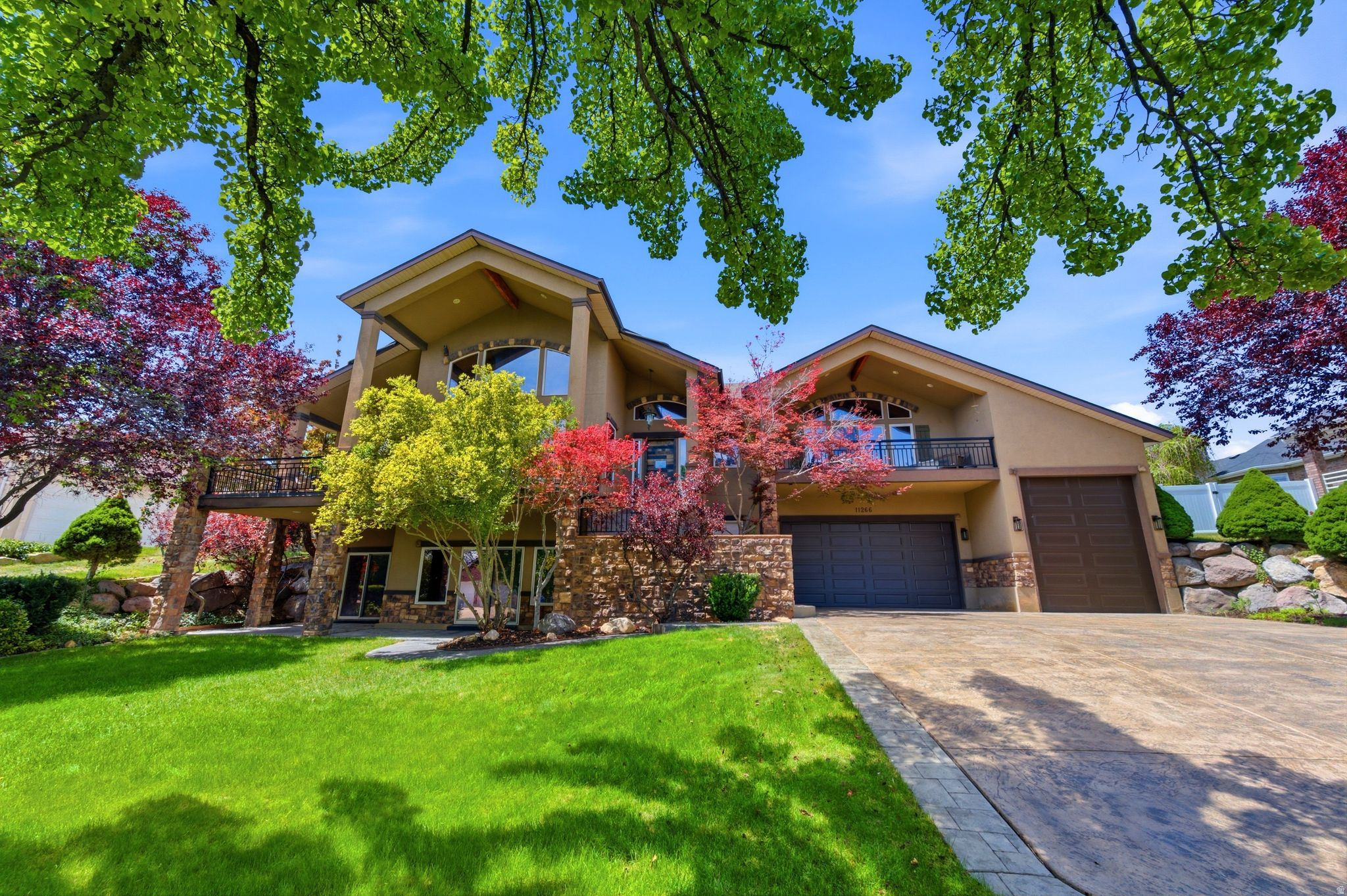 Stucco exterior with stone accents, featuring a prominent arched window and a balcony
