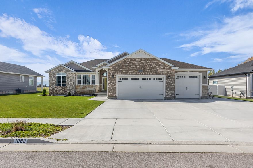 Welcome to 1092 East 250 South in Tremonton-a beautifully finished rambler offering over 3,200 square feet of comfortable, thoughtfully designed living space. This spacious home features six bedrooms, three bathrooms, two laundry rooms and a three-car garage, providing plenty of room for both living and entertaining. At the heart of the home is a custom gourmet kitchen, perfect for gathering and everyday living. The open layout and abundant natural light create a warm, inviting atmosphere throughout. Step outside to enjoy the 0.30-acre lot, complete with an open patio and stunning mountain views-ideal for relaxing evenings or hosting guests. This home combines space, style, and scenery in one exceptional property. Square footage figures are provided as a courtesy estimate only and were obtained from Seller records .  Buyer is advised to obtain an independent measurement.