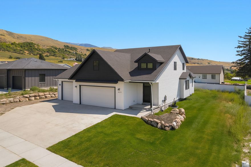 HUGE price adjustment! This home is priced well below market value! ** Matterport tour attached to this listing so you can truly get a feeling for this home!**   Conveniently located just 15 minutes from downtown Logan, and just  6 minutes from Cherry Peak Ski Resort  (with summer concert series).    This 7 bedroom home is nestled in a peaceful neighborhood with striking mountain views! A few steps across the street brings you to a cozy park and playground area.   In the 3 car garage you will find  epoxy coated floors  with a rare mechanics pit,  a dream set up for car enthusiasts!  The fully finished  walkout  basement has 3 bedrooms, a full bath and a brand new kitchenette. This (ADU) Mother in Law apartment has its own private entrance outside, but can also be accessed from inside should you chose not to rent it out.   On the top floor you will find 3 bedrooms, a full bathroom and a bonus loft!  The oversized loft  would make a great playroom, hobby area or an extra bedroom!  The main floor boasts an open floor plan with the kitchen and living room.  Stainless steel appliances. The spacious master suite features a large bathroom with a  separate tub and shower, and  walk in closet.  Bonus : 220 hook up in the garage along with  hot tub hook ups outback, as well as tankless water heater and separate temperature controls for the top floor!  This home is a blank slate, just waiting for its new owners to put in the final touches to make it theirs!