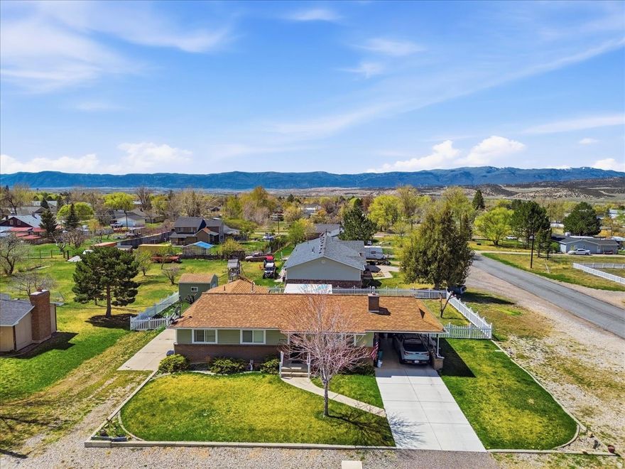 Spacious and well-maintained home featuring 5 bedrooms and 2 3/4 bathrooms, perfectly situated on a desirable corner lot with mountain views and a fully landscaped yard! This home offers a bright, open feel with large windows throughout, bringing in an abundance of natural light. Enjoy outdoor living at its best with a beautiful deck just off the kitchen, complete with a pergola-ideal for relaxing or entertaining. The fully fenced yard includes a full sprinkler system, mature apple trees (both red and green varieties), a garden shed, and a brand-new driveway. Inside, you'll find a functional layout with the convenience of laundry rooms both upstairs and downstairs. Recent updates include new siding, rain gutters, soffit, fascia, and a sliding glass door (all completed in 2019), along with a newer HVAC system installed in 2019. The kitchen features a new refrigerator and brand-new microwave. Riding lawnmower is negotiable. This move-in ready home offers space, comfort, and great upgrades-don't miss your chance to make it yours!   Square footage figures are provided as a courtesy estimate only and were obtained from Sanpete County.  Buyer is advised to obtain an independent measurement.