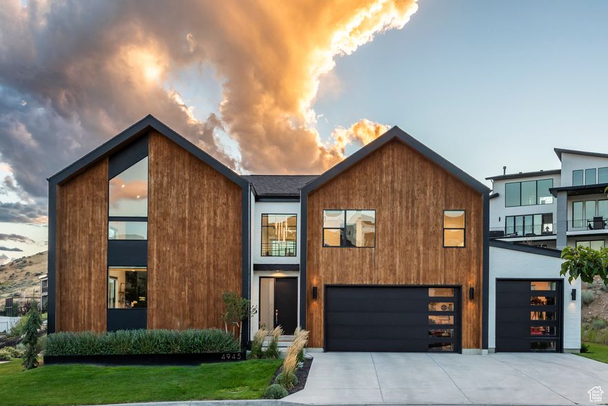 Modern Scandinavian Elegance on Traverse Mountain! Perched atop the prestigious Vialetto community, this Scandinavian Modern masterpiece redefines luxury living with breathtaking views of Silicon Slopes and Utah Lake. Every detail of this custom-designed residence reflects unparalleled craftsmanship and cutting-edge style. Step into the awe-inspiring great room, where 25-foot ceilings, exposed steel beams, and ambient LED lighting create a striking first impression. A floating staircase serves as a centerpiece, seamlessly connecting the open-concept living spaces. The gourmet kitchen is both functional and stunning, boasting commercial-grade appliances, Quartzite countertops, and a hidden Butler's pantry - perfect for effortless entertaining. The two-story family room, anchored by a Venetian plaster fireplace and rich wood flooring, offers a panoramic backdrop of city lights and mountain vistas. The main level is home to a serene Owner's Retreat, complete with plush carpeting, an expansive walk-in closet, and an adjoining laundry room for ultimate convenience. The spa-like en suite bath features a custom walk-in shower with Brizo brass fixtures, bespoke cabinetry, and porcelain countertops designed for relaxation and indulgence. Upstairs, a lofted office and children's lounge overlook the lower level, enhancing the home's airy design. Two additional bedrooms, a stylish bathroom, and a spacious entertaining area with a walkout deck provide both comfort and stunning valley views. The newly finished basement takes entertainment to the next level with a sleek, moody aesthetic. A kitchenette equipped with a Fisher & Paykel double-drawer dishwasher, ambient lighting, and a custom backsplash complements a built-in entertainment center with a hidden door leading to extra storage. This level also includes two bedrooms and bathrooms, offering a private retreat for guests or family members. The home's exterior is equally impressive, with distinctive modern design, lush landscaping, and breathtaking views from every vantage point. Located moments from upscale shopping, fine dining, and convenient freeway access, this architectural gem combines the serenity of mountain living with the vibrancy of city life. Don't miss the opportunity to own this one-of-a-kind treasure on Traverse Mountain.