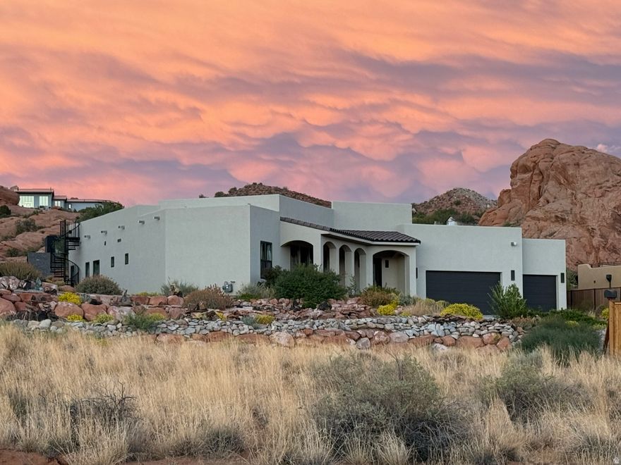STUNNING MODERN LUXURY LIVING with panoramic views from the ROOF TOP DECK. Tucked in a quiet cul-de-sac among towering red rocks, this spectacular property includes a giant red rock formation right on the property providing natural privacy. It features multiple patio, decks and covered front veranda for ultimate outdoor living. This beautiful home was designed with comfort and views in mind. Every room commands a view of the towering red rocks and the iconic Moab Rim. The floor plan flows seamlessly through the light-filled rooms with soaring ceilings, gas fireplace, large Anderson Black on Black 100 series windows and Pella Metal Clad French Doors. The kitchen is a chef's dream with expansive white oak cabinets, Quartz countertops, 5 burner gas stove plus wall oven, and a massive 9' x 5' island. Convenient to the kitchen is a huge pantry with built-in shelves for all your storage needs. The primary bedroom features large windows and french doors for easy access to the back patio. The en-suite bath is luxurious with porcelain walk in shower, soaking tub with chandelier and extensive Quartz counter with dual undermount sinks. With 3 more spacious bedrooms, there is plenty of room to comfortably accommodate all your guests. The oversized 3-car garage provides room for all your vehicles and Moab toys. From the elevated patio in the red rocks to the amazing roof top Duradeck set up with power, lighting, gas stub and hose bib, this property has the ultimate setting for rooftop entertainment, sunset viewing, star gazing and soaking in the incredible views. All info is deemed to be reliable, but buyer to verify all.