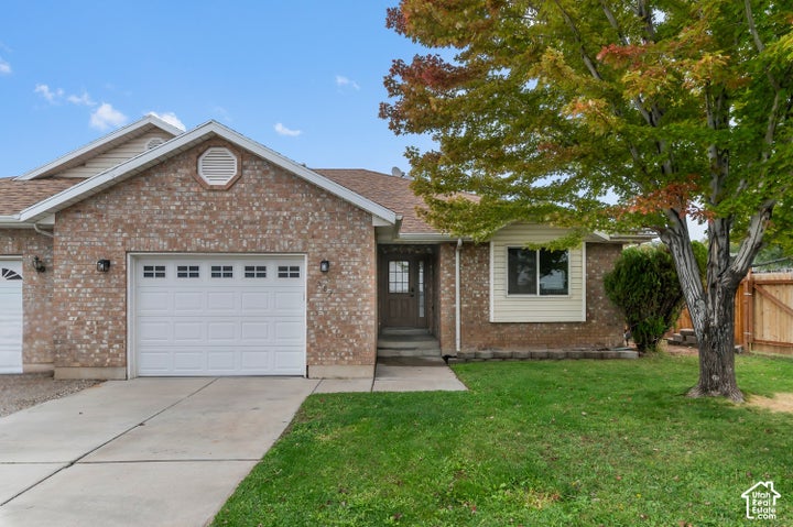 Brick veneer exterior with horizontal siding accents, an attached garage, and concrete driveway