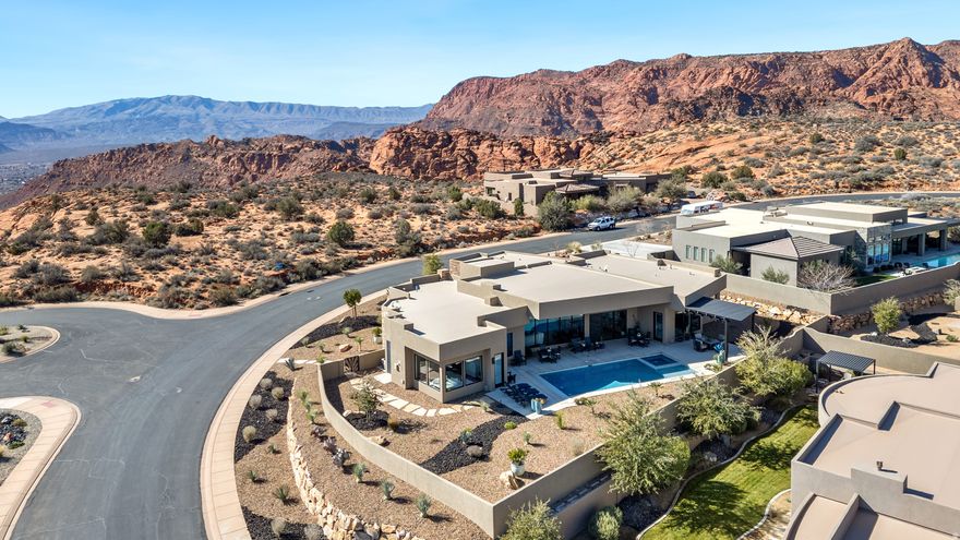 An inspired, one of a kind masterpiece in every respect, this stunning built custom home is located in the prestigious gated Westside of The Ledges. Designed to impress while offering comfort and privacy, the property features a private 16 x 36 pool and spa, a beautiful gazebo, and generous covered patio spaces that capture breathtaking mountain, red rock, golf course, and desert views.  The dramatic, thoughtfully designed dream kitchen is both striking and functional, showcasing custom cabinetry, a French door oven, steam oven, induction cooktop, hidden walk in pantry, and all custom appliances included. A soaring 12 foot floor to ceiling fireplace anchors the main living space, complemented by gallery walls, commissioned fused glass art details, and expansive windows that flood the home with natural light and create seamless indoor outdoor living. The seller has also added additional cabinetry and shelving for enhanced storage and functionality.  The luxurious primary suite offers a true spa like retreat with a soaking tub, towel warmer, and walk in shower with multiple shower heads. A private casita bedroom and bath includes a separate entrance, built in cabinetry, and its own outdoor sitting area, perfect for guests or multigenerational living.  The fourth bedroom has been thoughtfully designed as an entertainment or media room, offering flexibility for lifestyle needs. The oversized three car garage is filled with natural light and views, with the third bay currently outfitted as an office while still allowing space for golf cart parking, or it can easily be converted back to a full third garage bay.  Modern contemporary design and custom details are found throughout the home. HOA fees include common area landscaping, private roads, and gated security. The Ledges gated Westside is also a designated dark night sky community, offering a truly special living experience under the Southern Utah stars. Furniture is included with the right offer, excluding a few personal items.