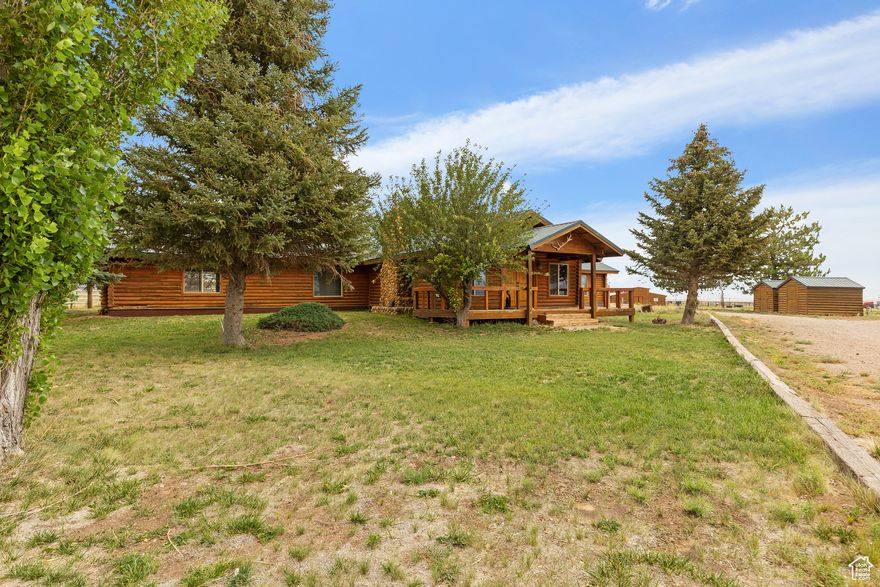 This horse facility offers privacy, unobstructed mountain views, and reliable water access. The property includes a spacious log home, mature trees, and a well-maintained layout designed for ease of use and safety. Improvements include all pipe fencing, solid gates, and a practical setup for managing horses and livestock. The barn features three tack rooms, two concrete saddling areas, a front-side concrete wash pad, and direct access to a 60' solid-walled round pen and a 180' x 385' arena with quality sand footing. Each of the horse and cattle pens is equipped with frost-free spigots and electrical service for year-round functionality. Additional features include a large shop with concrete floors, 220V power, an adjacent Conex container, and multiple storage buildings throughout the property. Water access supports both residential and operational needs.