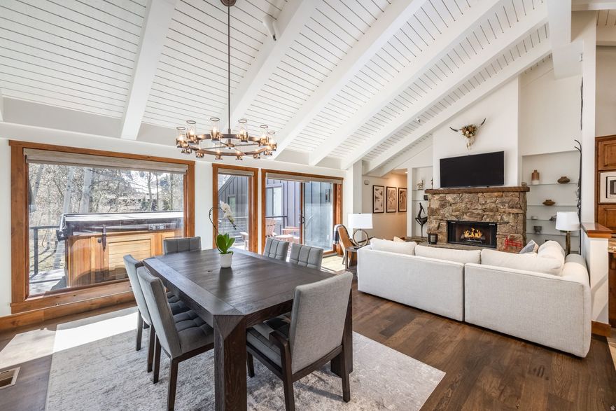 Welcome to this updated 3-bedroom, 2.5-bath townhome in the highly sought-after Queen Esther neighborhood of Lower Deer Valley. Ideally located adjacent to HOA open space, this property enjoys added privacy along with beautiful south-facing views of Deer Valley Resort from a large private deck, complete with a hot tub for relaxing after a day on the slopes or trails. Inside, the home features a spacious open floor plan with high ceilings that create an airy and inviting feel. The main living area is centered around a stunning stone fireplace, perfect for cozy mountain evenings. Two ensuite bedrooms offer comfort and privacy, while an additional bunk room and half bath provide flexible space for guests or extra sleeping capacity. Recent exterior renovations throughout the Queen Esther development include new roofs, siding, and stone, allowing for a low-maintenance ownership experience with strong community appeal. Sold fully furnished and turnkey, this property is ready for immediate enjoyment as a primary home, mountain getaway or investment property, as nightly rentals are permitted.  Whether you're skiing at Deer Valley, hiking and biking nearby trails, or taking advantage of the convenient shuttle to Snow Park for summer concerts, this location delivers effortless access to the best of Park City living in every season.