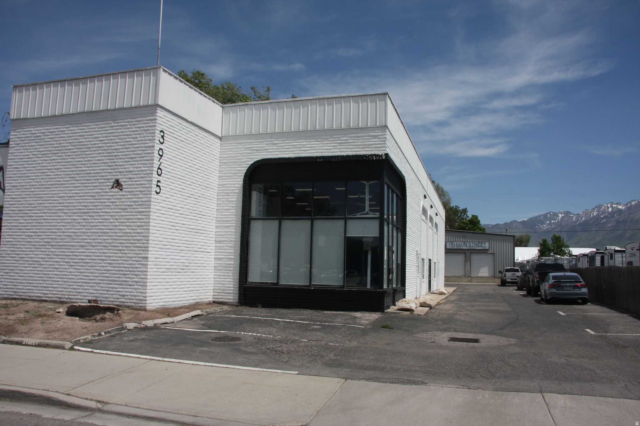 Commercial building with white brick facade and corrugated metal accents