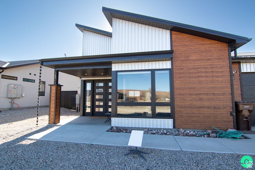 Experience modern desert living in this stunning single-level home in Spanish Valley, recently approved for Nightly Rental Zoning. Featuring a private pool and an attached 288 sq ft ADU-perfect for guests, income, or a home office. The 1,930 sq ft main home boasts 18-ft vaulted ceilings, a sleek quartz kitchen with induction cooktop, and energy-efficient design throughout. Enjoy premium details like under-cabinet lighting, pendant-lit nightstands, and vertical glass garage doors. Outdoor living includes a concrete patio, gas fire pit, hot tub, and fenced pool area. Pre-wired for solar and designed for comfort, this home is the perfect Moab retreat.