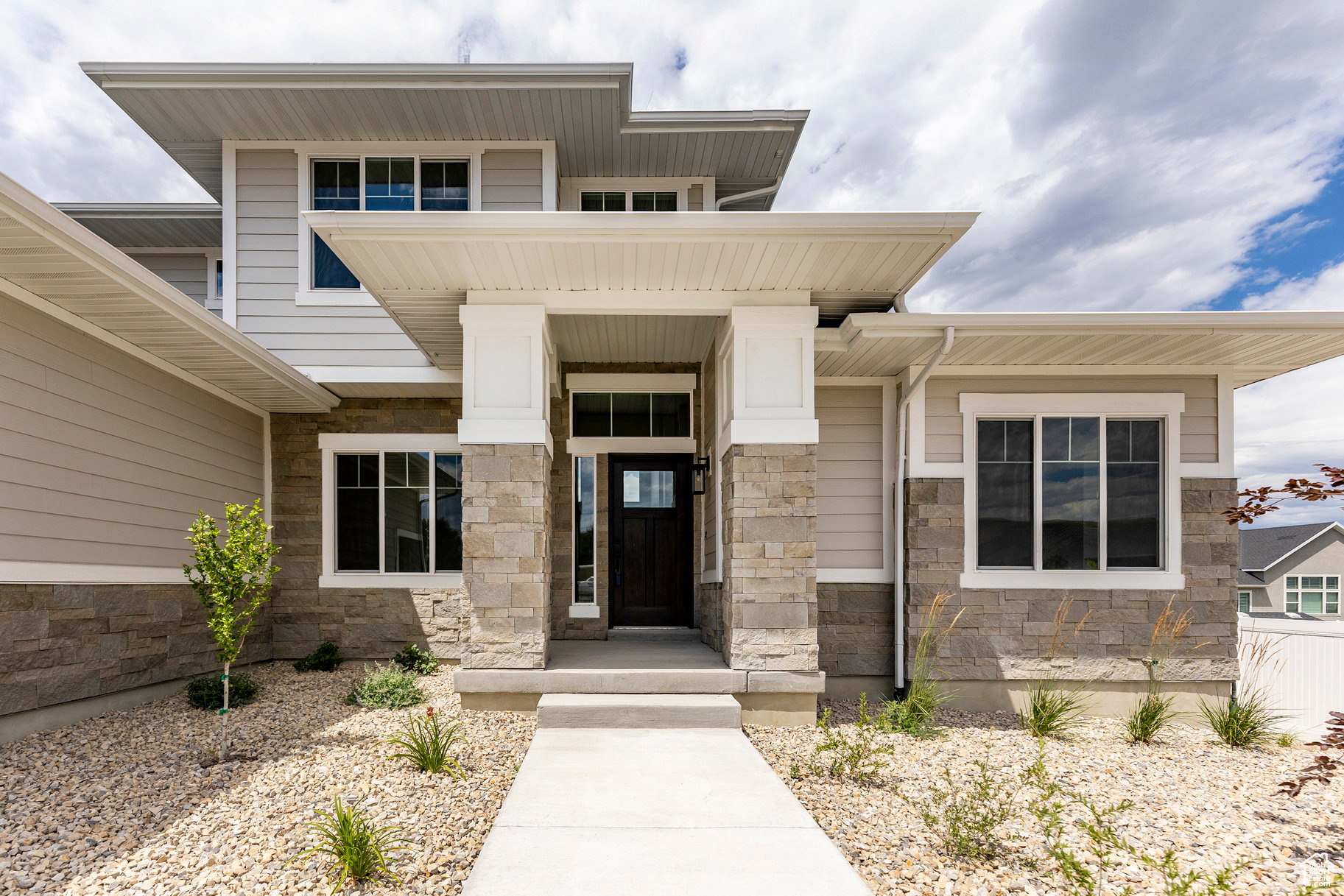 Imagine an afternoon basking in the sun on your expansive 1/3-acre south-facing lot, where your dream home stands as the perfect backdrop. As you approach, you're greeted by meticulously landscaped grounds and an impressive 4-car garage that promises functionality and style. For the car enthusiast or adventurer, the second bay extends a remarkable 36 feet deep, providing ample room for at least four vehicles, recreational toys, or a prized collection-making this home the ultimate haven for your automotive passions. Step inside to an open-concept great room with soaring two-story ceilings. Natural light pours into the space, creating an inviting atmosphere for relaxation and entertaining. The gourmet galley kitchen is a chef's delight, featuring a spacious island bar, a massive walk-in pantry, a gas cooktop, double-wall ovens, and a cozy dining nook-ideal for family meals and lively gatherings. The luxurious primary suite serves as a serene retreat, highlighted by a sophisticated tray ceiling, a spa-like garden tub, a separate shower, and an expansive walk-in closet, bathed in natural light from its own window. A flexible room off the entry, featuring a decorative grid wall, offers endless possibilities as a home office, additional living space, or hobby room-catering to your unique lifestyle needs. Thoughtfully designed for practicality, the large laundry and mudroom seamlessly combine style and function, ensuring easy organization. Beautiful hardwood floors flow throughout the main living areas, leading to the large covered deck, where stunning mountain views provide a serene backdrop for outdoor entertaining, summer barbecues, or quiet moments of reflection. The finished basement is fully stubbed for a future wet bar or kitchen, and offers generous storage space-creating the perfect environment for family activities or a private retreat. With minimal ongoing construction in the nearly completed neighborhood, you'll enjoy a mature and peaceful environment, coupled with access to excellent schools, parks, and an unbeatable location.