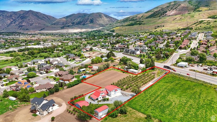 This large home is something very amazing and unique with no element overlooked. The owners went all out on this refurbished historic home, keeping a balance of the original charm and detail work but adding quality modern amenities. The lot has  2.75 acres, large garden open space, large peach tree orchard, and 10 shares of water rights. Outside you will enjoy great mountain views to the east and beautiful sunsets to the west. There is a detached shop for tinkering in or storing things. The detached living unit with kitchen, heating and AC is perfect for an ADU, man cave, she shed, or a detached office/work area.  Inside boasts main floor living with 5 beautiful bedrooms and 3 1/2 bathrooms. The spacious primary suite located on the main floor has its own bathroom, laundry, and garage access.  . Large open kitchen and formal dining area. Lots of storage spaces throughout. There is a large living area above the garage for all kinds of uses. The area has a full kitchen, bathroom, bedroom and large open area, perfect for an ADU, gatherings, work, the possibilities are limitless. The oversized garage is fully finished, has a thermostat controlled heater. The 11' tall doors on the pull through garage is a perfect amenity to this huge garage.