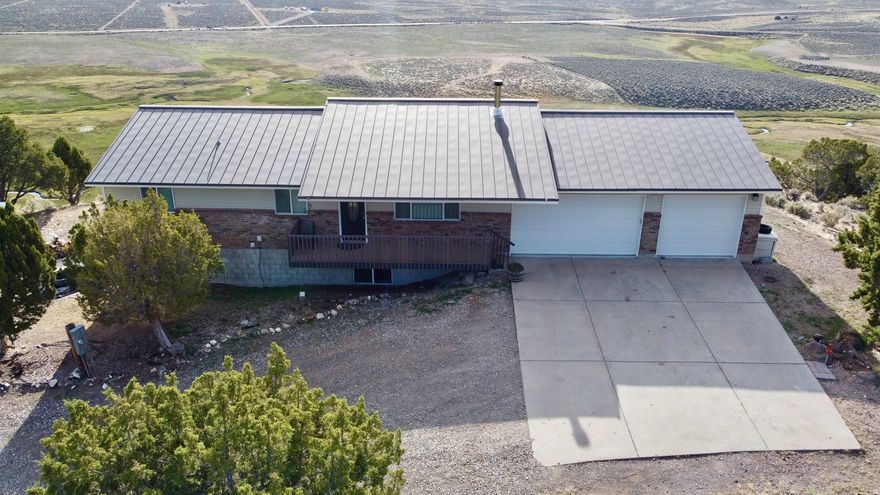 If you want views that truly stop you in your tracks, this is the place.  Set on the east side of Burrville Hill overlooking Koosharem Reservoir, this 4-bedroom, 3-bath home rests on 20.00 acres of open ground and big Utah sky. The setting alone is hard to beat - quiet, private, and perfectly positioned to capture those unforgettable east-facing sunrises rising over the water.  Inside, you'll find a well-appointed kitchen, warm and inviting living spaces, and a wood-burning fireplace that makes winter evenings feel exactly the way they should. Propane heat keeps the home comfortable year-round.  Step onto the east-facing deck and you'll immediately understand what makes this property special - wide open views, fresh air, and room to breathe.  The home offers a 2-car attached garage plus a large detached garage, providing ample space for vehicles, recreational toys, storage, or a workshop. A dedicated game room adds flexibility and includes a Murphy bed, making it ideal for additional guests or multi-purpose use.  Whether you're looking for a full-time residence, a secondary home, or a private retreat, this property offers the rare combination of acreage, privacy, functionality, and truly unforgettable views - all in one remarkable location.