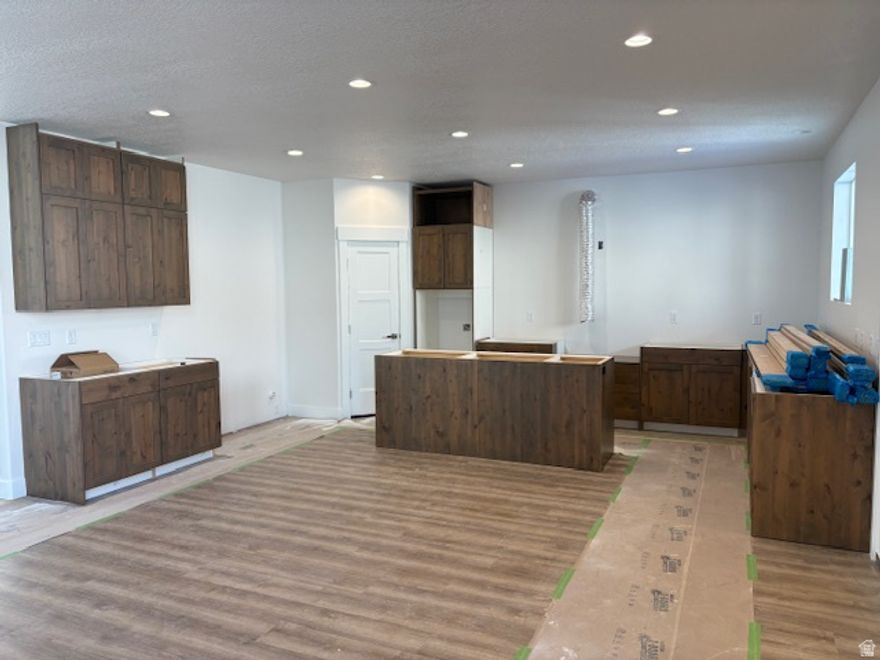 This beautifully finished expansive 7-bedroom rambler offers the perfect blend of space, style, and functionality. The heart of the home features custom cabinetry with soft-close doors, elegant hardware, and glass-front accents, paired with a gourmet kitchen equipped with premium appliances, including a built-in 66" refrigerator/freezer combo. The vaulted great room is light and inviting, highlighted by a cozy gas-log fireplace and 9' ceilings that extend through both the main level and basement. Retreat to the luxurious primary suite with a separate soaking tub, oversized shower, double vanities, and a generous walk-in closet. The fully finished basement adds incredible flexibility with a second kitchenette, four additional bedrooms, a full bath with double sinks, and a second laundry room-ideal for guests or multi-generational living. ADU options with a walk out basement. Complete with a spacious 4-car garage featuring an EV charging outlet, concrete RV pad, this home truly has room for it all.