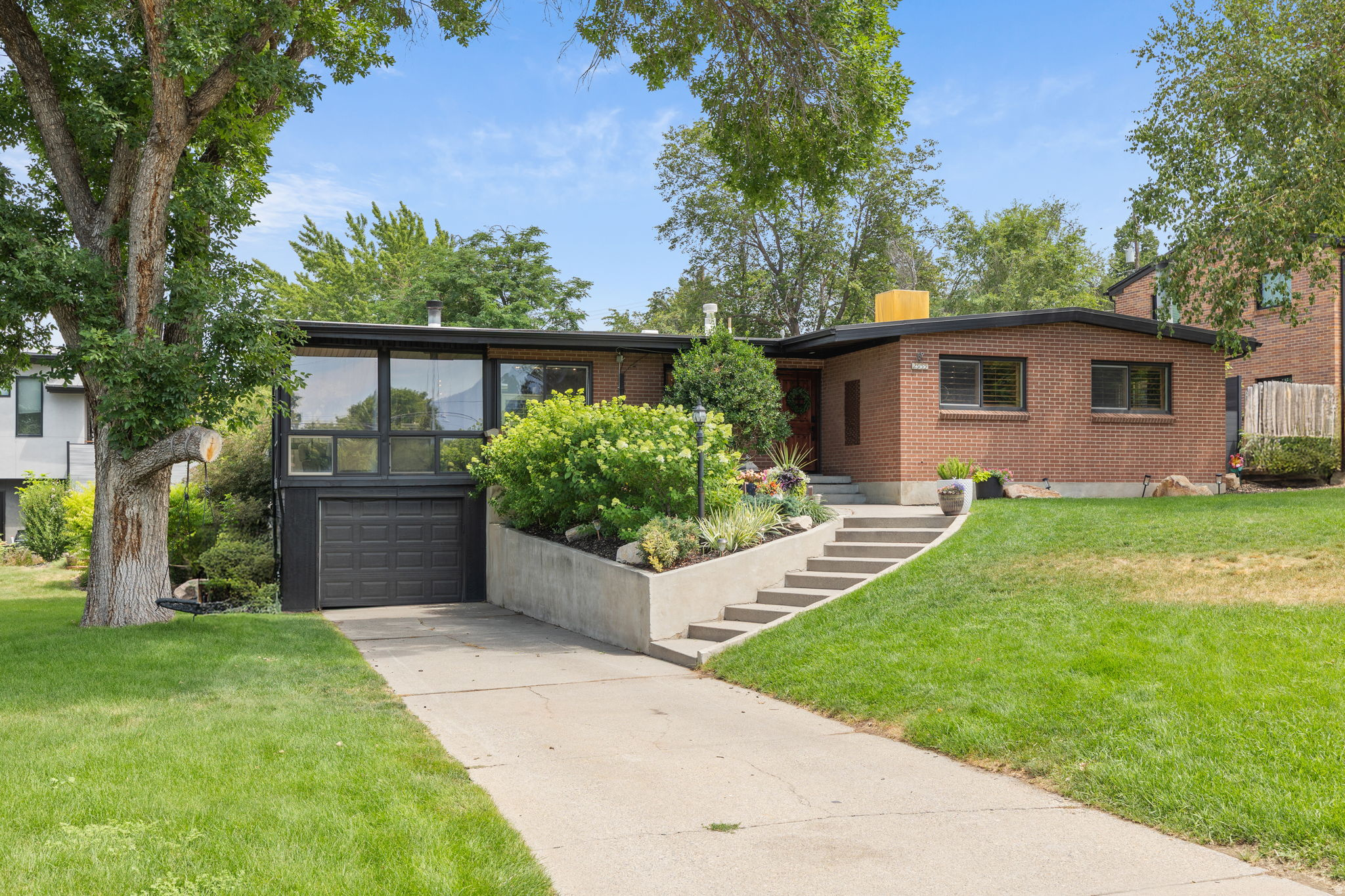 Mid-century modern residence featuring brick and dark-framed extensive windows