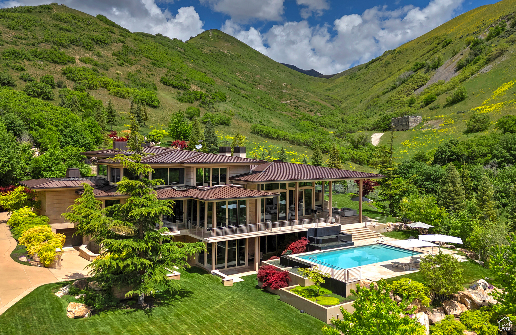 Lustrous on the canyon edge with limestone, glass, and gleaming metal, this distinctive, classically modern home honors its sense of place on 25 acres amid open space on Salt Lake City's Federal Heights bench. Despite its urban proximity, the 12,000-square-foot home is its own private retreat sited to savor the views of the city. Connections extol outdoor living as spacious as the home with a mountainside waterfall, balconies, a swimming pool with a cascading edge, planter-edged patios, and an exquisitely complete outdoor kitchen. The calm, subdued interiors offer a home for generous entertaining with large connected sitting areas that flow together and outside through the disappearing glass doors. At the same time, the 2,200-square-foot primary suite retains privacy. Three large suites accommodate guests and family, and a bar, recreation room, theater, exercise room with spa, and multiple gathering rooms complete the home's livable luxury. The award-winning Crestron smart-home system simplifies and automates all audio, visual, and lighting throughout the home. Unrivaled in location, design, and custom finishes. Simply the finest home in the Salt Lake Valley.