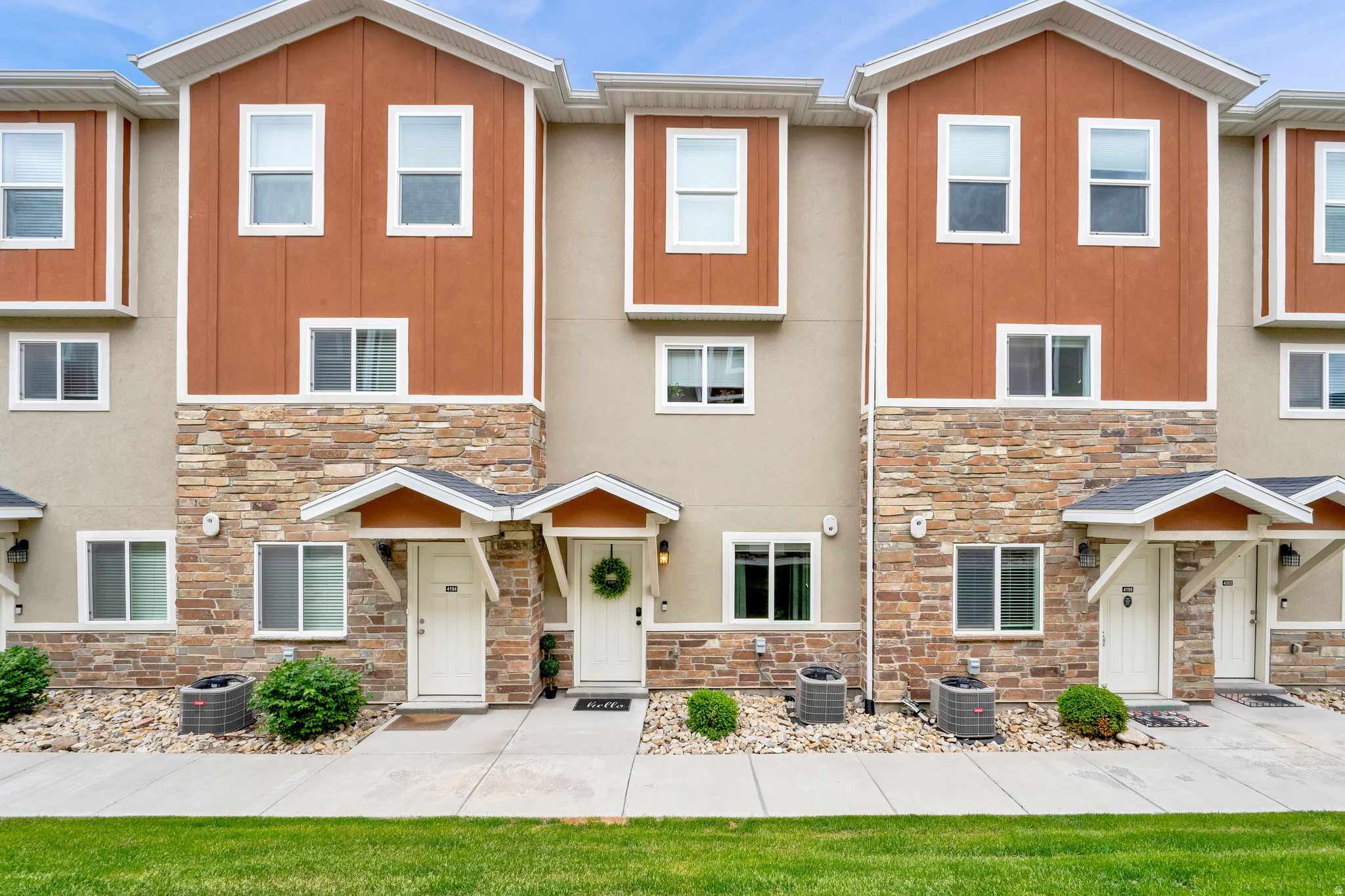 Townhome exterior featuring earth-toned siding and stone veneer accents