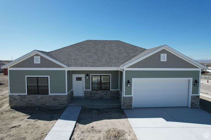 This modern new construction home features a traditional style with a basement, boasting a sleek and contemporary aesthetic with white, gray, and chrome fixtures. The interior includes three bedrooms, two bathrooms, and a two-car garage, with both bathrooms featuring double sinks. The kitchen is equipped with all-new G.E. stainless steel appliances, Corian countertops, and a farm-style kitchen sink. Additional amenities include a pantry, closet organizers, and a special kitchen wastebasket cabinet. The exterior features a spacious back patio accessible from both the master bedroom and dining room and the home is plumbed for a water softener and has garage electric outlets for an electric vehicle charger.