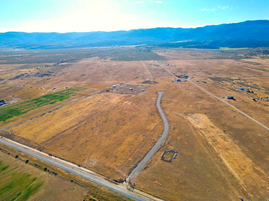 Welcome to one of Sanpete County's most distinguished new ranchette communities. Where 5+ acres of fully usable, irrigable land provide an exceptional setting for a custom estate. Designed for those who value space, privacy, and refined rural living, this exclusive subdivision offers a rare balance of luxury and agricultural versatility, all within 45 minutes of Utah County. Each thoughtfully planned parcel features a shared well with water stubbed to the lot, pressurized irrigation ideal for small pasture or large garden, power, and high-speed fiber internet, all conveniently stubbed and ready for connection. Whether your vision includes horses, livestock, gardens, or small-scale agricultural use, these properties offer the infrastructure and acreage to support it-without sacrificing comfort or connectivity. A paved asphalt roadway leads through a remote-controlled gated entrance, welcoming you into a private enclave framed by panoramic mountain and valley views in every direction. With wide-open space, irrigable ground, and utilities already in place, these lots are perfectly suited for a luxury country estate, equestrian property, hobby farm, or private retreat. Opportunities like this are increasingly rare in Sanpete County, combining irrigable acreage, modern utilities, gated privacy, and breathtaking scenery in one exceptional offering. Seller is willing to offer contributions toward the buyer's closing costs and/or interest rate buy-down with a full-price offer. All information within is provided as a courtesy only. Buyer and Buyer's Agent are advised to complete their own due diligence. Property boundaries and lot lines are shown as approximate.