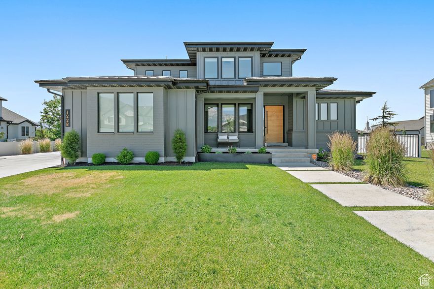 Located in the premier Timp Hollow neighborhood of American Fork, this Modern Prairie-style home offers a rare blend of comfort, functionality, and design. Just a short walk from American Heritage School and Lincoln Academy, the home is perfectly situated near schools, shopping, and American Fork Canyon. Inside, a gourmet kitchen anchors the main floor with marble island and countertops, double wall ovens, oversized built-in refrigerator and freezer, convection cooktop, and pot filler. Soaring double-height, south-facing windows bring in natural light while minimizing afternoon heat. The primary suite feels bright and open, with a spacious en-suite bathroom. Upstairs, three bedrooms and a loft provide flexible living space. The backyard is designed for year-round enjoyment: a covered patio with fireplace, in-ground trampoline, putting green, King Kool cold plunge, and a custom-painted New Primitive Sauna that matches the home's exterior. Additional RV parking adds flexibility. The basement features 9-foot ceilings, an exterior entrance, and a working salon that can be converted into a second kitchen, offering endless possibilities for customization. With its exceptional design, prime location, and unique amenities, this home in Timp Hollow is truly one-of-a-kind.