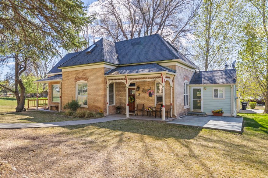 Step into a piece of Utah history with this beautifully preserved 1901 home, perfectly situated on a corner lot in the highly sought-after community of Spring City. Known for its charm, tree-lined streets, and designation as a historic district, Spring City offers a rare blend of small-town living, rich heritage, and timeless appeal, making it one of the most desirable locations in Sanpete County. This 2,100 sq ft home features 4 bedrooms and 2 full baths, combining classic character with thoughtful updates. Inside, you'll find original moldings, beautiful hardwood flooring, and the warmth and craftsmanship only a historic home can offer, paired with modern comforts including a newer furnace, central air, and a recently updated water softener system with de-chlorination. The home offers exceptional versatility and space for gathering, featuring a formal living room, separate family room, and an additional bonus room all on the main level-ideal for entertaining or flexible living. The inviting country-style kitchen is full of charm, highlighted by a beautiful accent brick wall that adds warmth and character. Comfort meets functionality with multiple heating options, including a wood/coal stove and a pellet stove, providing both efficiency and that cozy, rustic ambiance. The exterior is just as impressive, offering a rare combination of space and functionality. Enjoy a large, oversized detached garage, original smokehouse, chicken coop, and a charming fruit orchard surrounded by mature trees. Whether you're embracing a hobby farm lifestyle or simply enjoying the peaceful setting, this property delivers. A 300-gallon fuel storage tank is also included, adding convenience and practicality. Relax on the covered front porch, entertain on the wraparound deck, or unwind on the private balcony just off the primary bedroom-perfect for taking in Spring City's serene beauty and mountain views. A truly unique opportunity to own a piece of history in one of Utah's most beloved small towns, where character, community, and charm come together. All information within is provided as a courtesy only. Buyer and Buyer's Agent are advised to complete their own due diligence and independent measurements. Boundary and lot lines are shown as approximate.