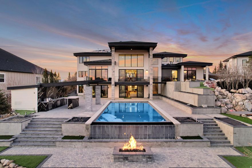 Perched at the top of Suncrest, this modern luxury retreat offers unmatched, unobstructed valley and mountain views from every room. Designed by Ezra Lee, the home blends elevated style with everyday convenience across more than 8,000 sq ft of thoughtfully curated living space. Vaulted ceilings and floor-to-ceiling windows flood the interior with natural light, while the gourmet kitchen features dual islands, double ovens, and an expansive pantry, perfect for both cooking and entertaining. The primary suite is a private sanctuary with an oversized walk-in closet, a spa-like bathroom with a sunken tub, a cozy fireplace, and a private deck with its own fire pit. Additional highlights include well-appointed bedrooms/bathrooms, an upper-level living area ideal for a home gym or game room, expansive decks/patios,  a custom bar, a secondary kitchen, a theater room, a home sauna, radiant in-floor heating, a walkout basement, and a four-car oversized garage. Outside, the home features an infinity pool, a full outdoor kitchen with barbecue, two fire pits, illuminated water features, and a putting green, all set against picturesque views. This estate truly has it all in addition to the amazing amenities the Suncrest Community has to offer.  Contact us today to schedule a private tour and experience one of the most exceptional properties in one of the market's most scenic neighborhoods.