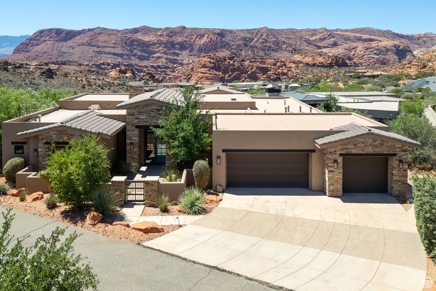 This beautifully designed custom built home offers the best of indoor comfort and outdoor living with stunning views, all set in the prestigious Ledges gated community. Step through a private courtyard and dramatic 16-foot foyer with steel beams and brick accents to find an open, modern layout with 12-foot ceilings, 8-foot windows, and sleek engineered European white oak flooring. The gourmet kitchen features White Ice granite and quartz counters, Wolf double ovens, a Sub-Zero fridge, hidden walk-in pantry, and a custom wood waterfall bar. The spacious primary suite includes backyard access, a large walk-in closet, and a spa-style bath with soaking tub, Kohler steam shower, and under-cabinet lighting. A separate casita offers its own entrance, 10' ceilings, designer tile shower, and Carrara marble vanity. Additional features include half bath with backlit Onyx countertop, smart home wiring (Google & Vivint systems), central vacuum, large laundry room with office nook, modern fireplace, built-in entertainment center, and a finished 3-car garage with epoxy floors and extended bays. Stackable sliders lead to a private backyard oasis with a 30'x20' pool (with Shamu shelf), spa, putting green, Wolf grill, covered patio, outdoor shower, and even an exterior half bath and storage room. This home blends luxury, style, and functionality in a setting that feels like a year-round vacation. On the bench above Snow Canyon State Park and less than 15 minutes north of the city of Saint George. This property is also a short drive to some of America's most breathtaking destinations, including Zion National Park, Bryce National Park, and the north rim of the Grand Canyon. Other nearby state parks and national forests, include Sand Hollow Reservoir, Gunlock Reservoir, Quail Creek Reservoir, and Dixie National Forest that enhance the allure of the location. With over 300 days of sun, incredible year-round weather, and in the middle of a 7,200 yard par 72 golf course designed by Matt Dye, there is no doubt that The Ledges is one of Southern Utah's best kept secrets. One of the best places to live for those who love the outdoors, biking, hiking, fishing, ATVing, and all other high-desert adventures. All information herein is deemed reliable but is not guaranteed. The buyer is responsible to verify all listing information, including square feet/acreage, to the buyer's own satisfaction.