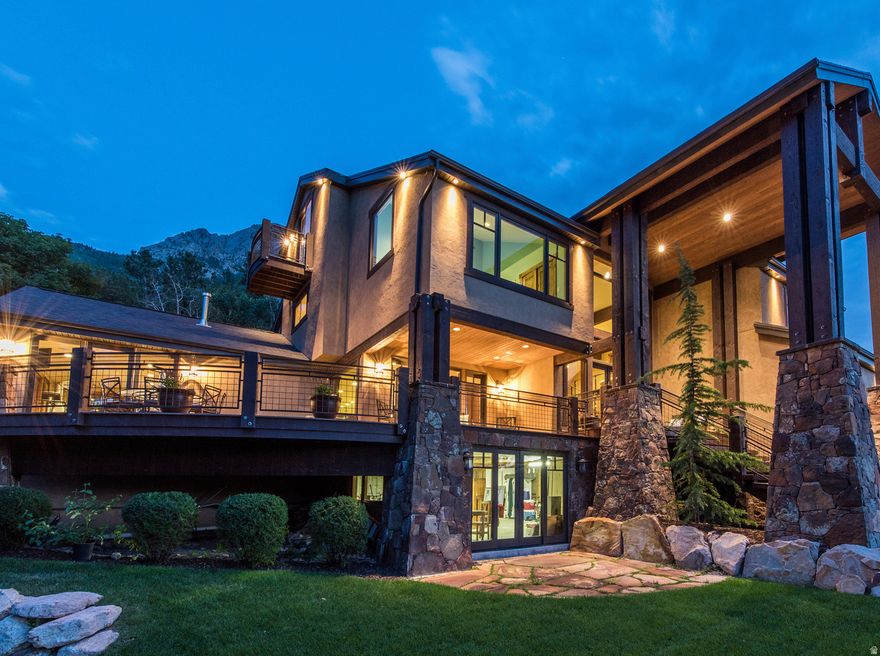 Custom luxury home located in Salt Lake City's highly sought-after Olympus Cove at the base of Mount Olympus, offering sweeping valley, city and mountain views and the end of the cul da sac. The main level is designed to maximize views and livability, featuring an open entry anchored by a floor-to-ceiling stone fireplace and expansive windows that frame the surrounding landscape. The kitchen includes a generous island, a full suite of high-end appliances, custom cabinetry, a large walk-in pantry, and adjacent main-floor laundry. A waterfall feature integrated into the exterior connects the home naturally to the mountainside and serves as a distinctive architectural element. A designated home gym overlooks the valley. The home offers 7 bedrooms and 6 bathrooms, including a spacious primary suite on the main level with deck access and an en-suite bath featuring dual vanities and a steam shower, as well as double walk in closets. The upper level includes two bonus spaces, one currently used as an office with incredible views overlooking Neffs Canyon.The fully finished walkout lower level provides additional living space, including a dedicated theater room, custom bunk room, additional guest bedroom, and a versatile bonus room suitable for recreation or entertaining. Ample custom built-ins are found throughout, along with a concealed temperature controlled wine room integrated into the bookcase. Additional upgrades include radiant in-floor heating throughout the main living areas, primary suite, driveway, and walkways, a home sound system, backup generator, play set, and hot tub. This elevated setting provides privacy while remaining conveniently close to freeway access, downtown Salt Lake City, Salt Lake International Airport, and year-round outdoor recreation.