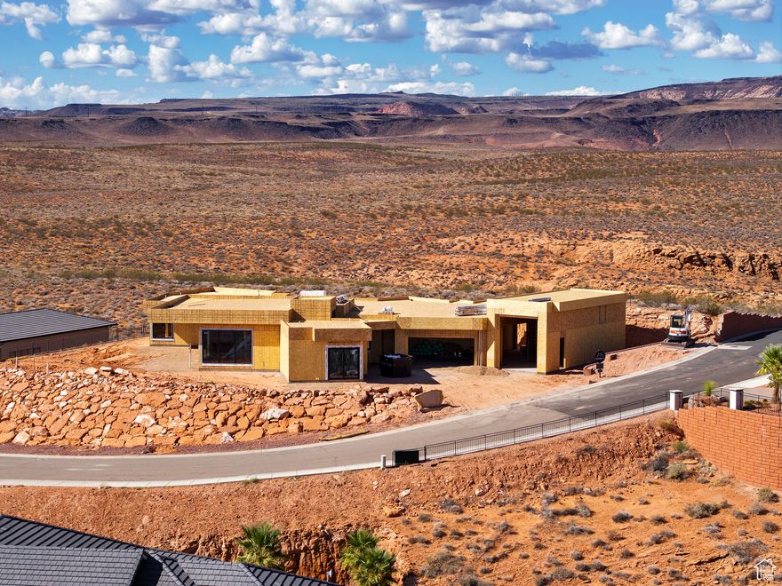 Perched near the top of the gated enclave- Westgate Hills, this single-level home takes in sweeping views of Pine Valley Mtn, sandstone cliffs, city lights & crimson ridges to the south. Set on a private -acre lot, it features a 43-ft RV garage w/12'x14' door, 3-car garage & RV pad. Outdoor living shines w/ heated pool, spa, waterfall feature, shamu shelf & auto cover. Inside: 5 beds (5th as office w/view), glass media room, private guest suite with incredible views, a chef's kitchen w/ custom cabinets, high-end countertops & appliances, large working pantry w/southern mountain views + an additional storage pantry. Primary retreat has a large window that perfectly captures Pine Valley Mtn views, has a spa-like bath & spacious closet w/ laundry hookups. Est. completion Jan 2026.