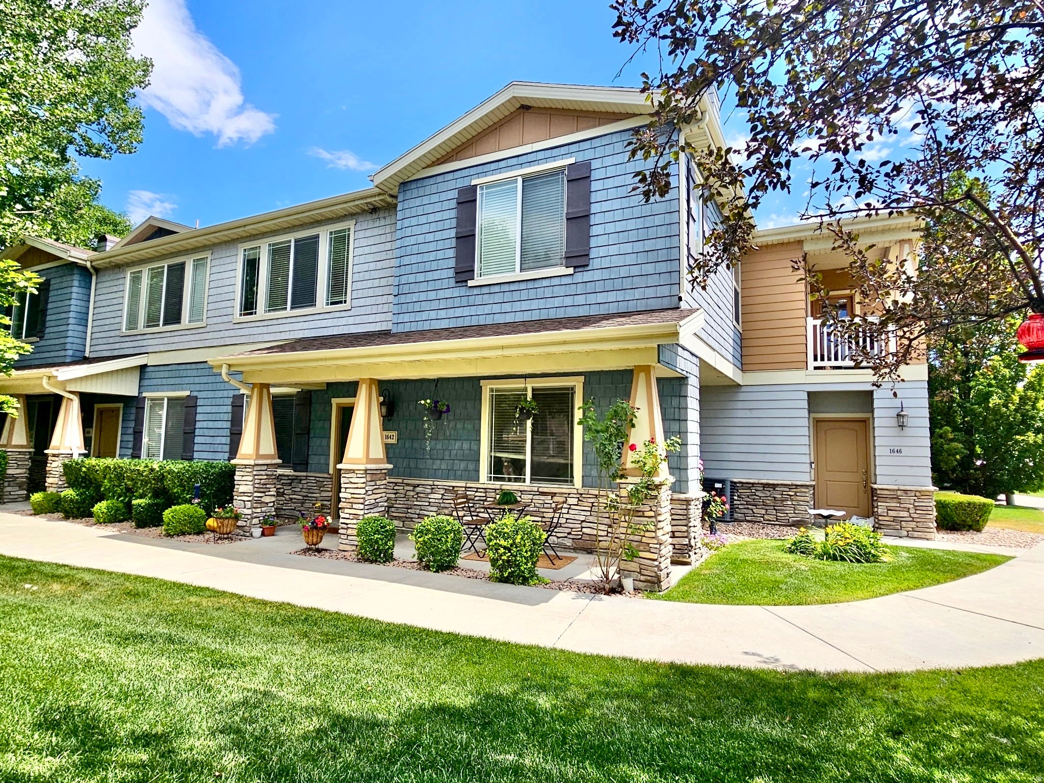 Multi-story townhome exterior featuring blue shake siding, light blue horizontal siding, and tan accents