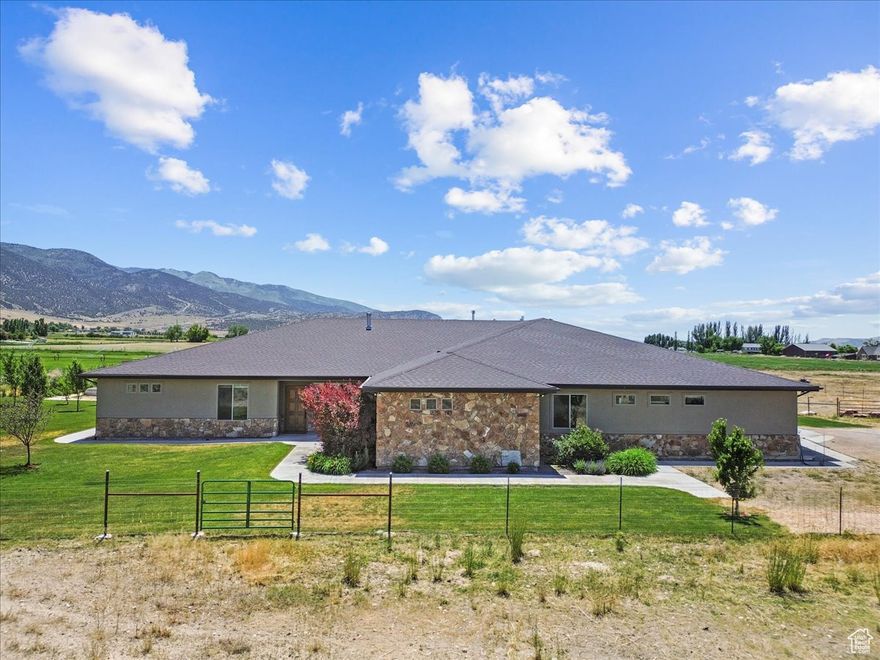 ***HUGE PRICE IMPROVEMENT!***This stunning custom home sits on almost 5 acres and is packed with charm, thoughtful details, and room for everyone. It includes two attached apartments-each with its own kitchen and thermostat-making it perfect for in-laws, extended family, or rental income.  Enjoy the convenience of single-level living with an airy open layout, 10-foot ceilings, wide doorways and hallways,  and huge energy-efficient windows that fill the space with natural light. The home is fully step-free and features two barrier-free showers, dual high-efficiency furnaces, HRVs, and top-tier R50 insulation.  Got toys or horses? The oversized 1,750 sq ft garage and 29 x 45  shed offer tons of storage. The property is beautifully landscaped with fruit trees, raised garden beds and automated irrigation. With panoramic mountain and valley views in every direction, this serene retreat is the ultimate blend of comfort, functionality, and beauty