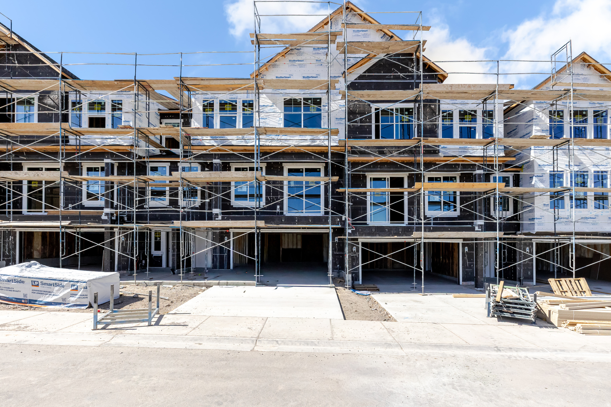 New construction townhomes featuring multiple large window installations and integrated garage spaces