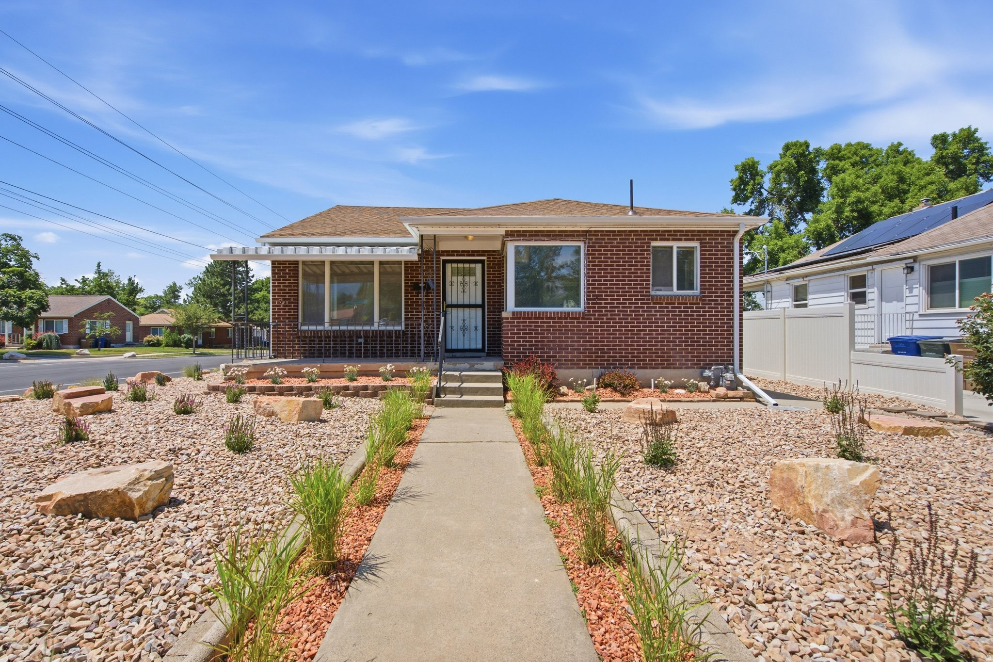 Brick exterior with a covered front entry featuring a security screen door