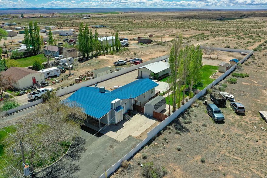 This beautiful property offers the perfect blend of comfort, space, and functionality, situated on over an acre of land. The home features 4 bedrooms and 2 bathrooms, along with a spacious family room that opens to a bright green room addition at the back of the house. Outside, you'll find a well-maintained acre with mature trees, attractive landscaping, a chicken coop, and a paved basketball court. The circular driveway provides easy access and plenty of parking, with ample space for recreational vehicles, equipment, and outdoor toys-plus room for animals to roam and enjoy. A standout feature is the fully equipped shop, complete with heating, workbenches, cabinets, and a convenient half bath-ideal for projects, storage, or business use. The backyard patio is already plumbed for a hot tub, making it ready for relaxation and entertaining. The home also includes under-eave lighting for added curb appeal and ambiance. Buyer and buyer's agent to verify all information.