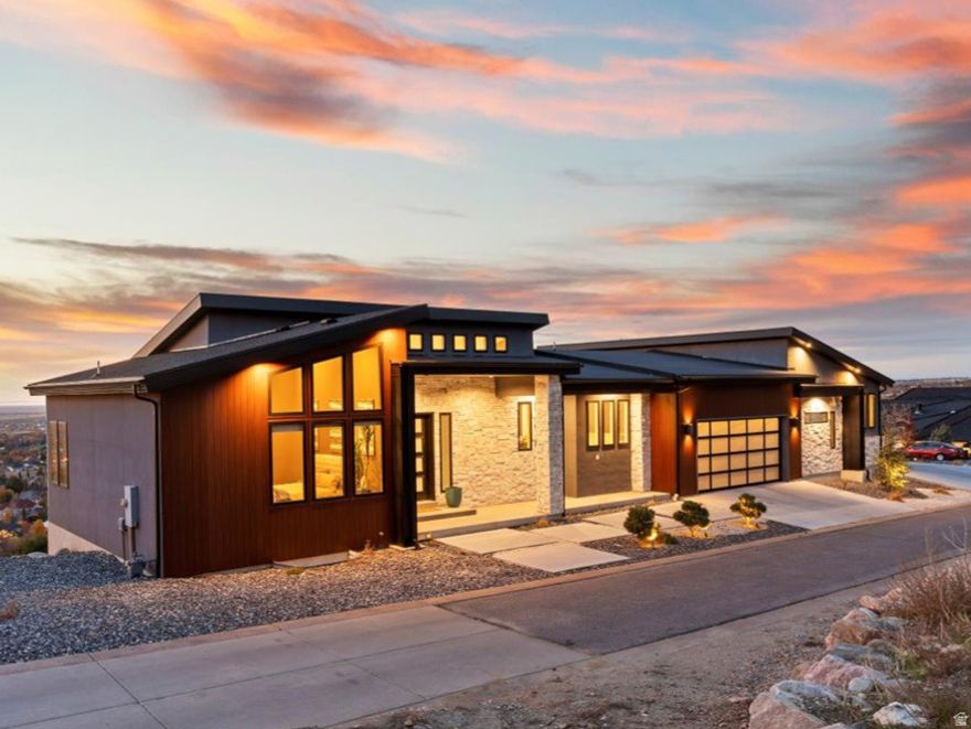 Private, Peaceful, Perfect in this distinctive custom built home in the Deer Crest at Hidden Springs Gated Community featuring handsome exterior of wood-look metal, stone and stucco, and unlimited views of the Great Salt Lake, valley and mountains! Thoughtfully designed home with single level living in mind, the interior indulges you with the expansive great room with electric fireplace with stone surround, 20' vaulted ceilings, beautiful tile flooring, upgraded lighting and ceiling fans, remote control window shades, dramatic kitchen with dark stained cabinets / double ovens / desirable 6-burner gas range with griddle / SS vent hood / tile backsplash / side-by-side refrigerator / center island with pendant lighting, plus additional refrigerator in the large walk-in butlers pantry, large open dining area. Double sliding glass doors lead to the full length epoxy coated covered deck with outdoor kitchen, romantic views, glass railings, fireplace and spiral staircase leading to lower patio. Primary bedroom with en-suite having marble floors, free standing soaking tub, marble shower, huge walk-in closet. Split floor plan with guest bedroom with walk-in closet and 3/4 bath. Laundry/mudroom complete the main level.  Suspended staircase with glass railings lead to the lower level featuring generous family room,  2 bedrooms and 1 full bath plus additional laundry room. Lots of potential for the 1,104 sq ft under the suspended garage!  Full length lower level covered patio too! Extensive 4- car garage, wired for 220, with glass garage doors. Home has $25,000 fire suppression system plus 19 caisson piers were installed for earthquake proofing costing $240,000. Owner open to including 4-wheeler with snow plow. The Hidden Springs community enhances your lifestyle with a clubhouse having a full kitchen, pool and hot tub, workout facility, and walking trails, all within close proximity to high-rated schools, Station Park Shopping Center, parks, and outdoor activities. Plus, with easy access to freeways and just 20 minutes to ski resorts and Salt Lake International Airport, convenience is at your fingertips. Owner/agent. Schedule via Aligned Showings.