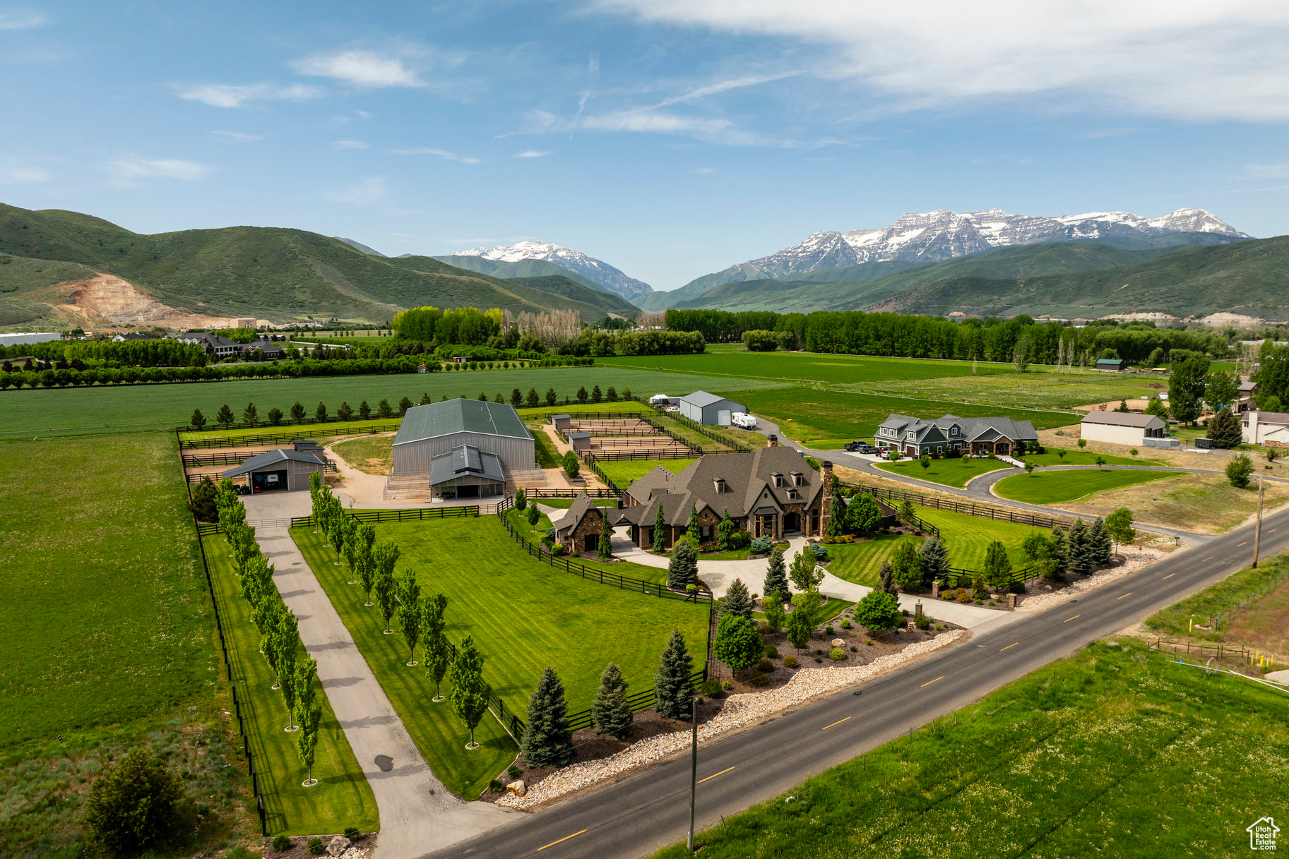 Discover your next unparalleled equestrian estate on 5.5 meticulously designed acres in the heart of Heber Valley, offering panoramic views of Mount Timpanogos and an unrivaled blend of luxury living and world-class horse facilities. Just 15 minutes from Park City's renowned ski resorts, minutes from fly fishing on the Provo River, boating on nearby lakes, and the Heber Valley Airport, this property is perfectly positioned for both recreation and convenience. The thoughtfully designed main level living residence offers modern comfort with dual laundry rooms, steam humidifiers, whole-home water filtration and softening systems, and refined finishes throughout. Designed in a timeless French Country style-unique to Utah-the home features soaring 10- and 12-foot ceilings, custom woodwork, and a large gourmet kitchen complete with wine fridge, double oven, and induction cooktop with gas option. The expansive master suite includes a sitting area with stunning views and a gas fireplace, while the luxurious master bath offers his and hers walk-in closets and a full-sized laundry area. A covered patio with a built-in Wolf BBQ and gas fireplace extends the living space outdoors, perfect for entertaining. The centerpiece of the estate is a fully insulated 36' x 64' MD Barnmaster Elite Barn with radiant gas heat, a 12' center aisle with hidden drains and rubber pavers, one oversized foaling stall, five 12' x 12' stalls each with 24' outdoor runs, LED lighting, ceiling fans, Ritchie heated waterers, a dedicated grooming and wash area with infrared heaters, a well-appointed tack room, feed and storage rooms, and a half bath with washer hookup. Attached to the barn, a 75' x 198' heated and insulated indoor riding arena boasts GGT footing, European shatterproof safety walls, full-width mirrors, MacroAir fans, LED lighting, sound system, automatic roll-up doors, natural light from large garage-style windows, dual freezeless water faucets, and a heated raised viewing area with quartz countertops. Outside, six large turnouts with loafing sheds and five irrigated grass pastures provide ideal conditions for equine health and happiness. This is a rare opportunity for the discerning equestrian buyer who values expert craftsmanship, functionality, and seamless access to Utah's finest outdoor lifestyle.