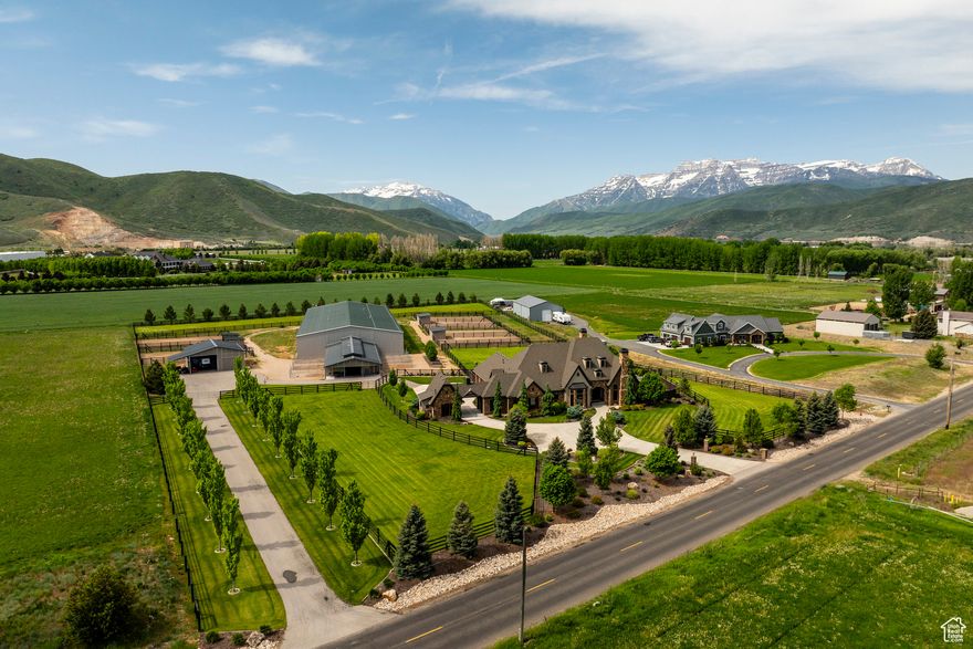 Discover your next unparalleled equestrian estate on 5.5 meticulously designed acres in the heart of Heber Valley, offering panoramic views of Mount Timpanogos and an unrivaled blend of luxury living and world-class horse facilities. Just 15 minutes from Park City's renowned ski resorts, minutes from fly fishing on the Provo River, boating on nearby lakes, and the Heber Valley Airport, this property is perfectly positioned for both recreation and convenience. The thoughtfully designed main level living residence offers modern comfort with dual laundry rooms, steam humidifiers, whole-home water filtration and softening systems, and refined finishes throughout. Designed in a timeless French Country style-unique to Utah-the home features soaring 10- and 12-foot ceilings, custom woodwork, and a large gourmet kitchen complete with wine fridge, double oven, and induction cooktop with gas option. The expansive master suite includes a sitting area with stunning views and a gas fireplace, while the luxurious master bath offers his and hers walk-in closets and a full-sized laundry area. A covered patio with a built-in Wolf BBQ and gas fireplace extends the living space outdoors, perfect for entertaining. The centerpiece of the estate is a fully insulated 36' x 64' MD Barnmaster Elite Barn with radiant gas heat, a 12' center aisle with hidden drains and rubber pavers, one oversized foaling stall, five 12' x 12' stalls each with 24' outdoor runs, LED lighting, ceiling fans, Ritchie heated waterers, a dedicated grooming and wash area with infrared heaters, a well-appointed tack room, feed and storage rooms, and a half bath with washer hookup. Attached to the barn, a 75' x 198' heated and insulated indoor riding arena boasts GGT footing, European shatterproof safety walls, full-width mirrors, MacroAir fans, LED lighting, sound system, automatic roll-up doors, natural light from large garage-style windows, dual freezeless water faucets, and a heated raised viewing area with quartz countertops. Outside, six large turnouts with loafing sheds and five irrigated grass pastures provide ideal conditions for equine health and happiness. This is a rare opportunity for the discerning equestrian buyer who values expert craftsmanship, functionality, and seamless access to Utah's finest outdoor lifestyle.