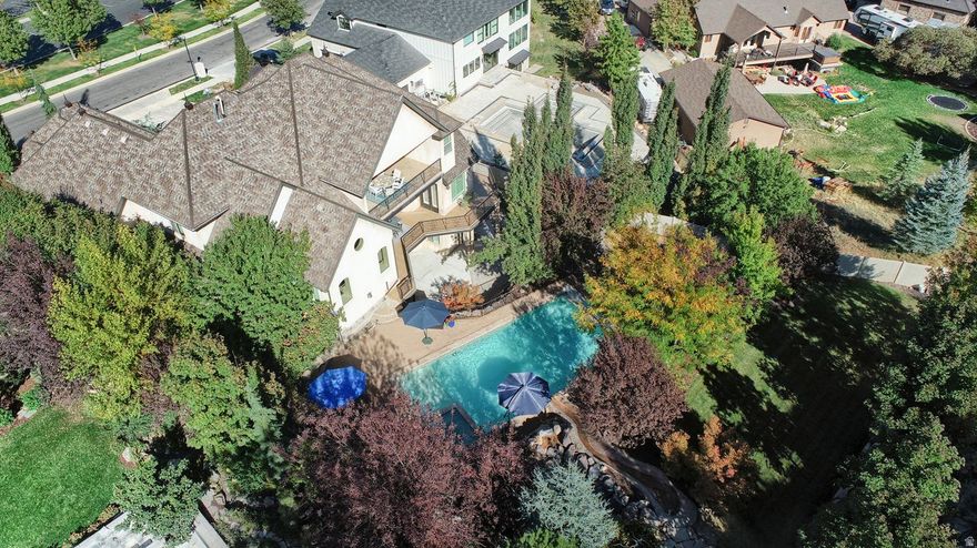 Discover refined living in this stunning custom Wow Thank you for this!!!! Open house this Saturday! Draper estate, offering over 8,000 sq ft of beautifully designed space in one of the area's most prestigious neighborhoods. Featuring 10-foot ceilings and 8-foot doors throughout, this home blends spaciousness with sophistication. Enjoy complete privacy in the backyard oasis, where a custom pool with built-in rockslide is framed by breathtaking, unobstructed views of the Wasatch Mountains-perfect for relaxing or entertaining. Inside, the main floor showcases a grand open-concept kitchen and family room with expansive windows that capture the mountain scenery. A large office and luxurious primary suite with plantation shutters and private covered patio complete the main level. Upstairs offers a second bedroom suite, three additional bedrooms, a theater room, and a second office that opens to a covered balcony with panoramic views. The walkout basement includes a full second kitchen, family room, game/den area, exercise or dance studio, craft room, steam shower, second theater room, and generous storage. This exceptional property is a rare find, combining space, privacy, and luxury in one of Draper's most desirable communities.