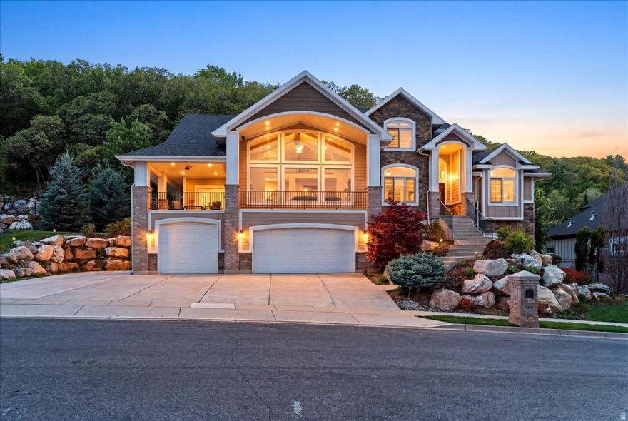 In-house Elevator gives you main-floor living on every level in a custom-built Davis County home featuring valley and mountain views, wraparound covered front and back decks, a private backyard with a natural gas fireplace and waterfall feature, and situated on .65 acres with a heated driveway. This Davis County property includes a fully finished basement with 10' ceilings, a custom elevator with access from the garage entry to all levels, and a 4-car garage with insulated doors, epoxy flooring, and a full-length floor drain. Offering 6 bedrooms, 4 bathrooms, multiple family rooms, abundant natural light, lage gathering spaces, and a custom theater room, this home is designed for both everyday living and entertaining. Interior and exterior surround sound speakers, three indoor gas fireplaces, engineered hardwood flooring, and a private office with leaded windows enhance the spaces. Two great rooms with 20' ceilings and expansive windows maximize natural light and mountain views, complemented by motorized shades. The kitchen features two-tone skyline cabinetry, upgraded granite countertops, subway tile backsplash, stainless steel appliances, double ovens, and a huge hidden pantry. The owner's suite includes private access to the back patio, tray ceilings, a gas fireplace, double vanity, oversized shower, separate jetted tub, and a spacious walk-in closet. The basement includes 10-foot ceilings, a theater room, abundant storage, a second laundry room, and is plumbed for a future kitchen and could easily be turned into a mother-in-law suite or ADU. Additional features include plantation shutters throughout, two attached storage rooms with access from the front and back patios, RV parking with electrical hookup, holiday exterior lighting, two HVAC systems (Furnace and AC), water softener, smart thermostat controls, three electrical panels, a security system with exterior cameras and alarm capability (subscription optional), and MyQ garage access. Located in a quiet South Weber neighborhood, tucked away from any canyon winds, and with convenient access to Highway 89, I-15, and the I-89 corridor, this home offers an easy commute to Hill Air Force Base, Ogden, and Salt Lake City, is only minutes from hiking and biking trails, approximately 20 minutes from Snowbasin Ski Resort, and close to multiple lakes.