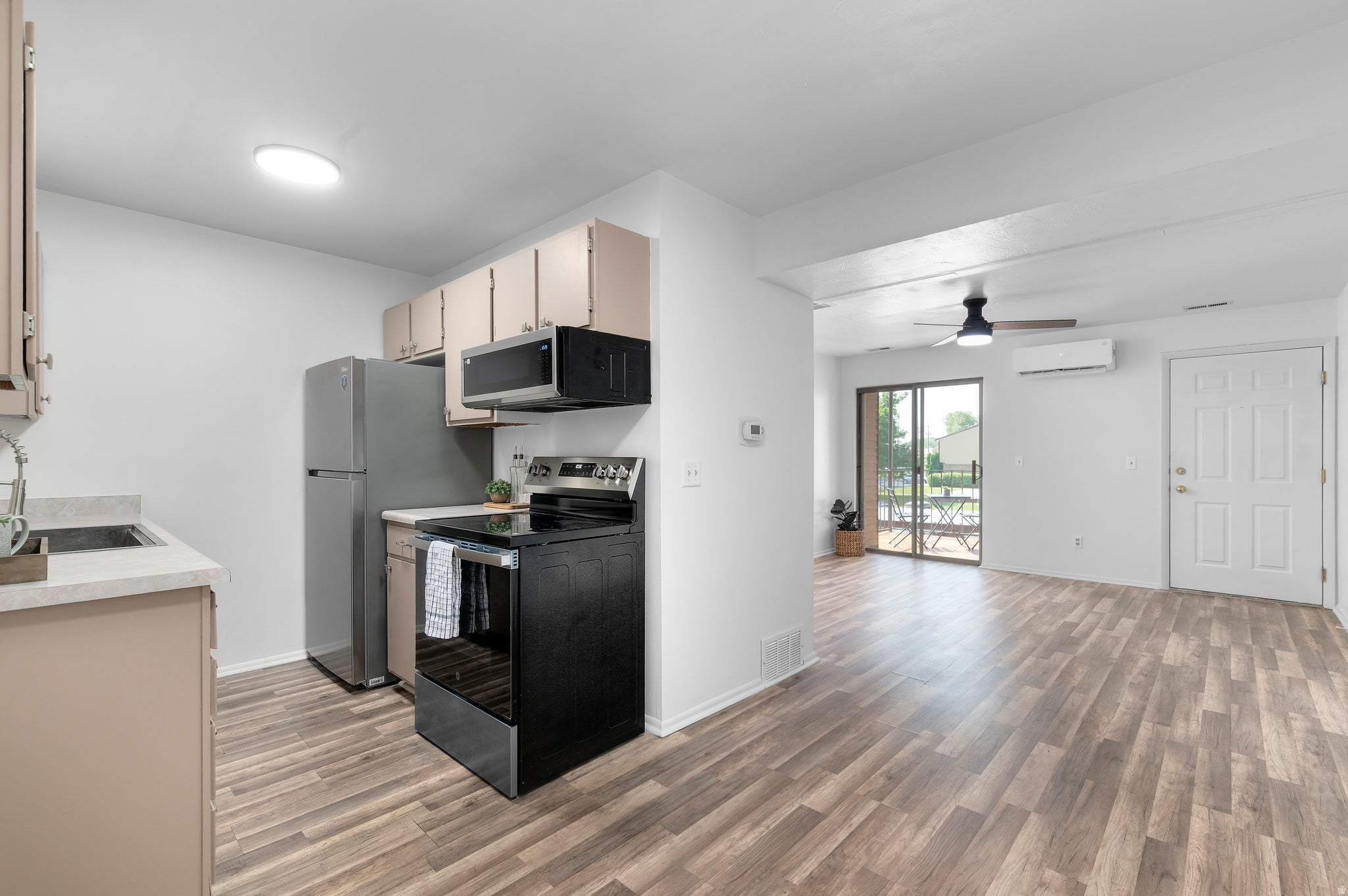 Open-concept living space featuring LVP flooring, a kitchen with stainless-steel appliances (included)