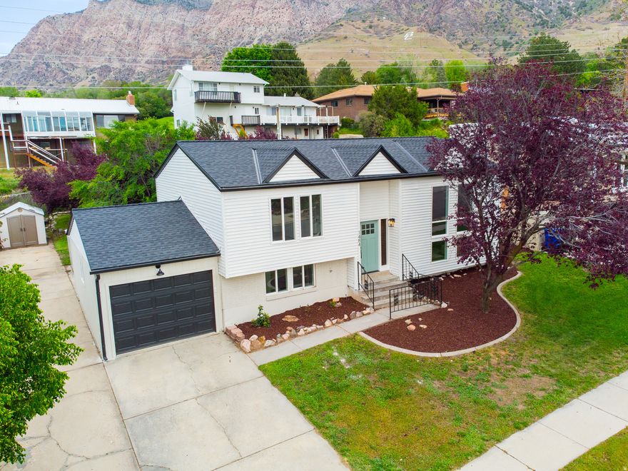 Completely transformed East Ogden home with a fresh designer vision! This property delivers a stunning top-to-bottom renovation with style and function in every detail! The exterior makes a bold first impression with designer paint fresh landscaping, and all-new windows, while inside you'll find a fully re-imagined and comfortable living space. The interior shines with a cohesive designer palette, custom handrails & banisters, plush new carpet, LVP flowing throughout, tile flooring, and modern lighting fixtures. The kitchen is a showstopper with new cabinetry, quartz countertops, tile backsplash, and all new stainless steel appliances, while the bathrooms feel like a luxury retreat with new tubs, vanities, mirrors, and striking custom tile work. Custom tile details also elevate the fireplace, adding a unique focal point to the living space. Large deck off the back of the house is great for entertaining and relaxing in the evenings. Every element has been thoughtfully curated by a professional designer, creating a polished, move-in-ready home that blends comfort, quality, and elevated design.