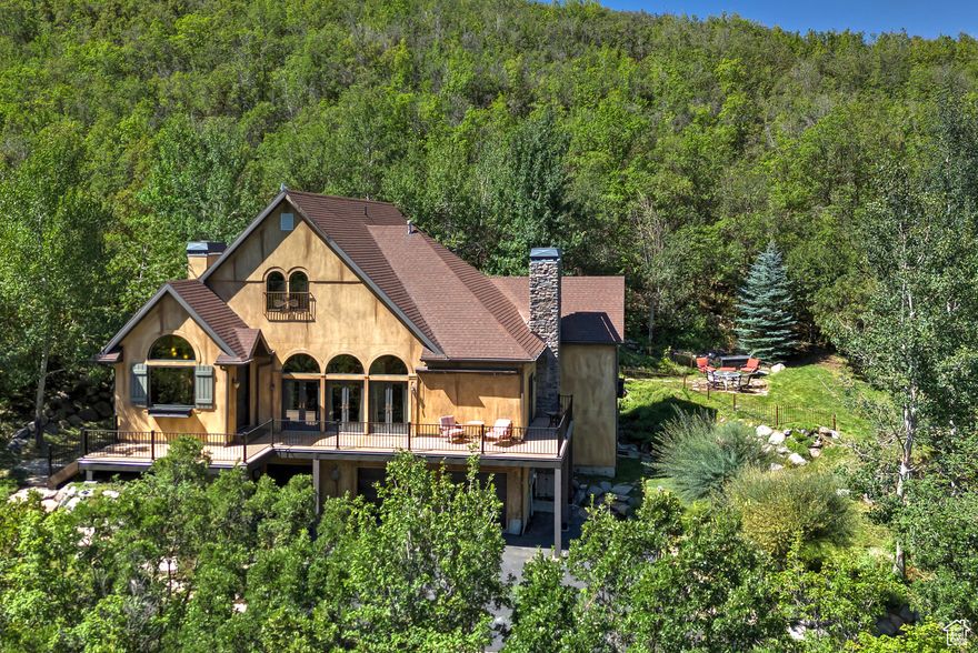 In the prime location of Emigration Canyon, this incredible two-story estate sits on one of the largest and most secluded lots at the end of a quiet cul-de-sac. A private hiking trail winds behind the home to the top of the ridge, delivering unmatched mountain views that stretch beyond the horizon. Inside, the open, flowing floor plan is awash with natural light, creating a bright, inviting atmosphere that ties the living spaces together with effortless ease. The wraparound deck extends from the north to the east, offering seamless indoor-outdoor living and panoramic views from multiple vantage points. This property features five bedrooms and six bathrooms, including a well-appointed mother-in-law apartment on the lower level, providing flexible living arrangements or added income potential. The home is designed for comfortable living and gracious entertaining, with thoughtful finishes, a chef-ready kitchen, and ample spaces for daily living or grand gatherings. The 1.23-acre lot is wonderfully private, ensuring tranquility while still being close to the amenities and outdoor recreation that make Immigration Canyon so desirable. Direct access to nature through your own trail is ideal for hiking, sunset strolls, and sunrise vistas, making this residence a true sanctuary.