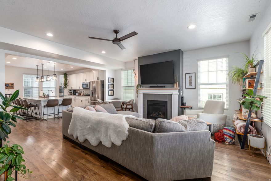 Discover modern living in the heart of Daybreak just steps from the lake, private fireplace pavilions, scenic walking trails, and an array of grocery, dining, and lifestyle conveniences all within a 5 minute walk. This beautifully designed home showcases premium quality materials throughout, featuring a 9' open-concept layout, stylish designer finishes, and a cozy gas fireplace that anchors the main living space. The chef-inspired kitchen is an entertainer's dream, complete with a double-wide quartz island with pendant lighting, gas cooktop, double ovens, and a large walk-in pantry for extra storage. Upstairs, the luxurious primary suite offers vaulted ceilings, a spacious walk-in closet, double sinks, and stunning mountain views. Your personal retreat to relax and unwind. Additional 2 bedrooms, bathroom, and linen closet for storage. Enjoy outdoor living year round beneath the spacious front covered porch, or host guests on the covered patio that leads to the 2-car garage, featuring a EV charging outlet and finished with durable epoxy flooring for a clean and polished look.  Square Footage figures are provided as a courtesy estimate only. Buyer is advised to obtain an independent measurements.