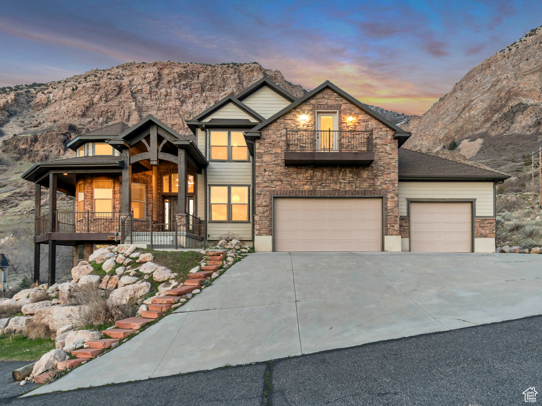 This rare find is located at the top of a long sweeping driveway, denoting opulence and privacy with no backyard neighbors and over an acre of mountainside. Entering the home, you will be struck by the gorgeous lighting and 2-story ceilings. The main floor features the primary suite with a one-step shower, a corner jetted tub with unobstructed views of the private backyard and mountainside, 2 walk-in closets, and a wall heater to make the bathroom extra cozy. Off of the primary suite is a sitting room overlooking the valley and looks out to the wrap-around porch that leads to the primary suite. Adjacent, the sitting room is a formal living room, den, or office. The living room and kitchen offer an open floor plan with a wall of windows looking out to the mountains and Jump Off Canyon. The kitchen features a large island with a second sink, double wall ovens, a gas five-burner cooktop, a built-in desk, lots of lighting, and a walk-in pantry. The main level also features 2 guest bathrooms, a spacious laundry room with cabinets, a sink, and a laundry chute from the upstairs. Upstairs are three spacious bedrooms, a large bathroom with double sinks, and a massive bonus/entertaining room or 5th bedroom with a Juliet balcony overlooking the valley. The 4-car garage is plumbed for heating, and there is lots of parking space to the side of the garage for an RV or a car enthusiast. With over an acre and no backyard neighbors, the vast covered trex deck has unbelievable views and the serenity of a private mountain oasis. In addition to these fantastic features, there is a VA Assumable Loan at 3.5%! If the buyer wants to assume the loan, they must have VA eligibility.
