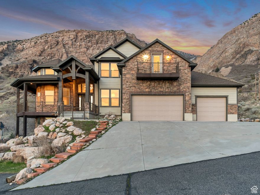 This rare find is located at the top of a long sweeping driveway, denoting opulence and privacy with no backyard neighbors and over an acre of mountainside. Entering the home, you will be struck by the gorgeous lighting and 2-story ceilings. The main floor features the primary suite with a one-step shower, a corner jetted tub with unobstructed views of the private backyard and mountainside, 2 walk-in closets, and a wall heater to make the bathroom extra cozy. Off of the primary suite is a sitting room overlooking the valley and looks out to the wrap-around porch that leads to the primary suite. Adjacent, the sitting room is a formal living room, den, or office. The living room and kitchen offer an open floor plan with a wall of windows looking out to the mountains and Jump Off Canyon. The kitchen features a large island with a second sink, double wall ovens, a gas five-burner cooktop, a built-in desk, lots of lighting, and a walk-in pantry. The main level also features 2 guest bathrooms, a spacious laundry room with cabinets, a sink, and a laundry chute from the upstairs. Upstairs are three spacious bedrooms, a large bathroom with double sinks, and a massive bonus/entertaining room or 5th bedroom with a Juliet balcony overlooking the valley. The 4-car garage is plumbed for heating, and there is lots of parking space to the side of the garage for an RV or a car enthusiast. With over an acre and no backyard neighbors, the vast covered trex deck has unbelievable views and the serenity of a private mountain oasis. In addition to these fantastic features, there is a VA Assumable Loan at 3.5%! If the buyer wants to assume the loan, they must have VA eligibility.