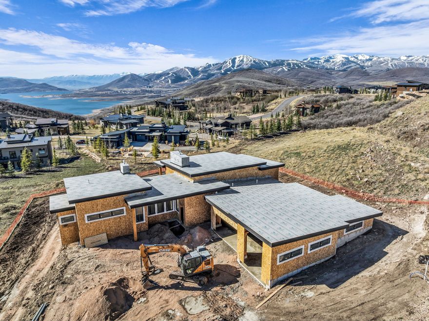 Jordanelle Lake views from this Mt contemporary new construction home in Deer Vista. Featuring over 6700 square feet with multiple covered decks & patios taking advantage of the outdoor setting and amazing views. The gourmet kitchen offers Wolf & Sub Zero appliances, double ovens, a gas range, 2 dishwashers, a large pantry & built BBQ while the main level offers a luxurious primary suite, office, laundry, a 4 season mudroom and 6 car garage making for an abundance of main level living. The lower level features the ultimate entertainment area including a second great-room, bar, game room and four additional on-suite bedrooms. Construction by Entrada Homes & Interiors by Intrigue Design allows for plenty client interaction.