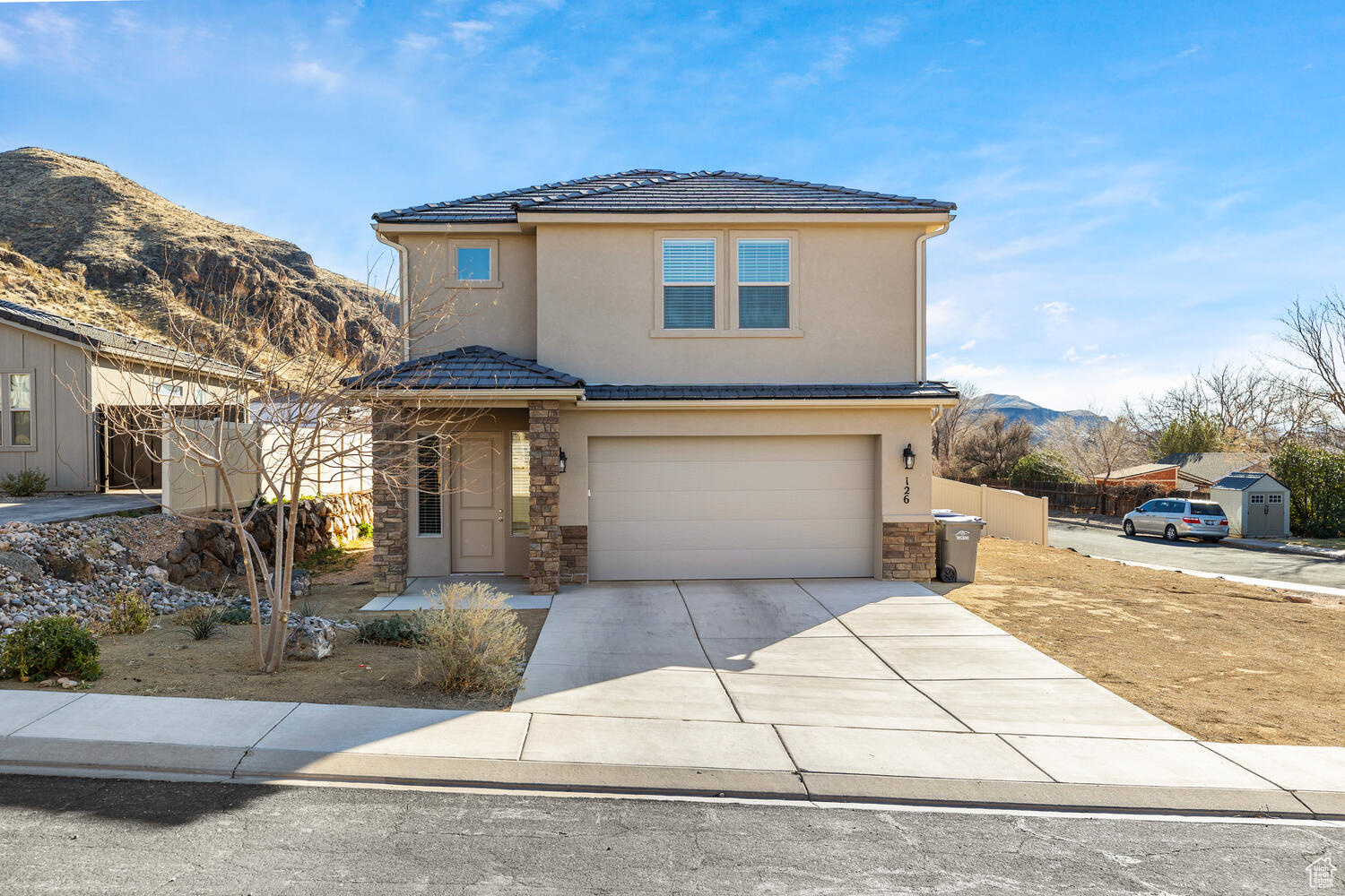 Nearly brand new construction meets flexible living in this contemporary 4-bedroom home, framed by breathtaking hill and mountain views. Completed in 2022 with no HOA, the property spans nearly a quarter acre, offering a large yard that could accommodate an ADU for added income. Inside, an open-concept layout unites living area, kitchen, and dining, complemented by durable LVP floors and abundant natural light. The chef's kitchen shines with contemporary Shaker cabinets, white quartz counters, stainless appliances, and a spacious breakfast-bar island.  Upstairs, the primary suite boasts a walk-in closet with custom organizers and an ensuite bath featuring double sinks and a walk-in shower. Two additional bedrooms share a hall bath, also with double sinks. A handy laundry room, ready for your washer and dryer, and a finished two-car garage with storage rack add convenience. Enjoy outdoor living in the covered back patio and low-maintenance yard, with upgraded fencing for privacy, all nestled in the scenic foothills of La Verkin Overlook. With local restaurants and amenities close by, plus Zion National Park just a short drive away, this home offers the perfect balance of scenic tranquility and everyday practicality. Come in, relax, and let each day unfold with a new adventure.