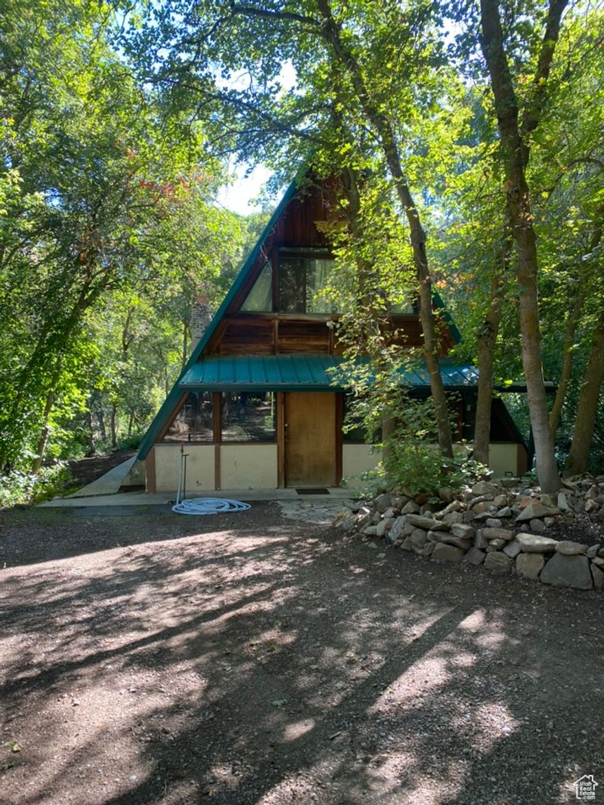 A-Frame that sits on a beautiful lot up Hobble canyon. Off the back deck you've have a lovely view of the river and 3 holes of Hobble Creek Golf Course. With this lot being wooded and full of pines you feel like your in a world of your own.  House needs MAJOR repairs. Water and electricity is connected with Springville city.  Sewer is on septic tank and propane has a 1,000 gal. tank thats buried on property.  Buyer is advised to obtain an independent measurement.  Square footage figures are provided as a courtesy estimate only and were obtained from an Appraisal.  Buyer is advised to obtain an independent measurement.