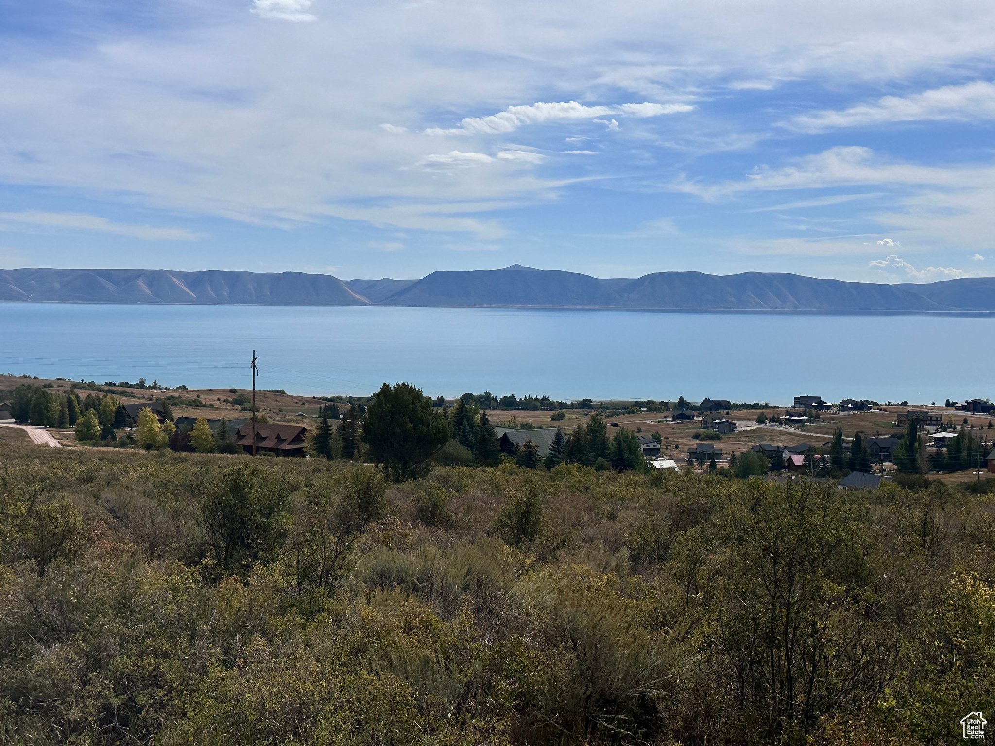Aspen Creek Estates 4.99 Acres with Panoramic Bear Lake Views Endless views stretch from north to south over Bear Lake from this premier 4.99-acre building lot in Aspen Creek Estates. Short-term rentals are allowed in this HOA, giving you both lifestyle and investment flexibility. The lot is improved with culinary water and power, with sewer to be septic. Multiple options exist for driveway access, making it an easy property to build on. Just minutes from your property into BLM and National Forest lands up Fish Haven Canyon.-ideal for hiking, ATV, and year-round recreation. This rare parcel offers both convenience and seclusion. Whether you're looking to build your private mountain-lake retreat or a rental income property, this lot has it all.