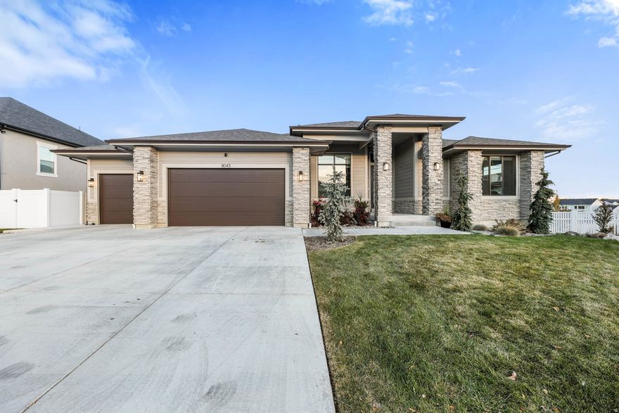 Welcome to 8043 Ambrosia Lane, where warmth and comfort meet luxury living! Nestled in an upscale West Jordan community this spacious rambler home boasts beautiful curb appeal with an elegant Prairie exterior and professional landscaping. Immediately you'll notice the difference in interior finishes when stepping into the 12' ceilings with a decorative beam tray in the living room! Other features include quartz countertops, double ovens, butlers pantry, custom cabinetry, 2 gas fireplaces and a large covered trex deck. The Owner's suite features a glass shower, oversized garden tub, and large walk-in closet. The finished basement has a true walkout to the back patio, a large family room/game room with a kitchenette. Community offers a swimming pool & playground and access to the Highlands Trail System.