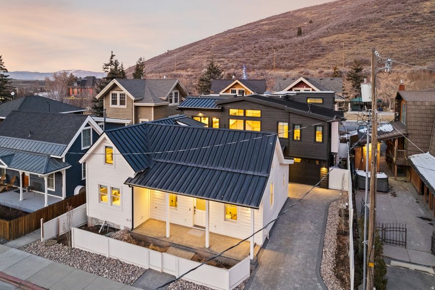 Following the historic 2022/2023 snowfall that collapsed the original 1904 miner's cottage, this property was reborn as a refined architectural estate-honoring its mining-era heritage while introducing a newly built main residence and guest casita totaling 6,300 square feet under roof. Set on a rare flat lot in Old Town Park City, this walk-to-everything location offers immediate access to City Park, Library Park, Main Street dining, and Park City Mountain ski runs. The 4-bedroom main residence features ensuite bedrooms, private theatre, game room, gym, wellness spa, office, and rooftop deck with panoramic ski run views. The 3-bedroom casita, built with salvaged historic elements, functions as a fully independent guest home. Four fireplaces-two in the main home, one in the casita, and one rooftop-anchor curated gathering spaces. Heated driveway, heated courtyard, and heated rooftop terrace provide year-round mountain living. An irreplaceable Old Town luxury compound blending historic preservation with modern mountain design.